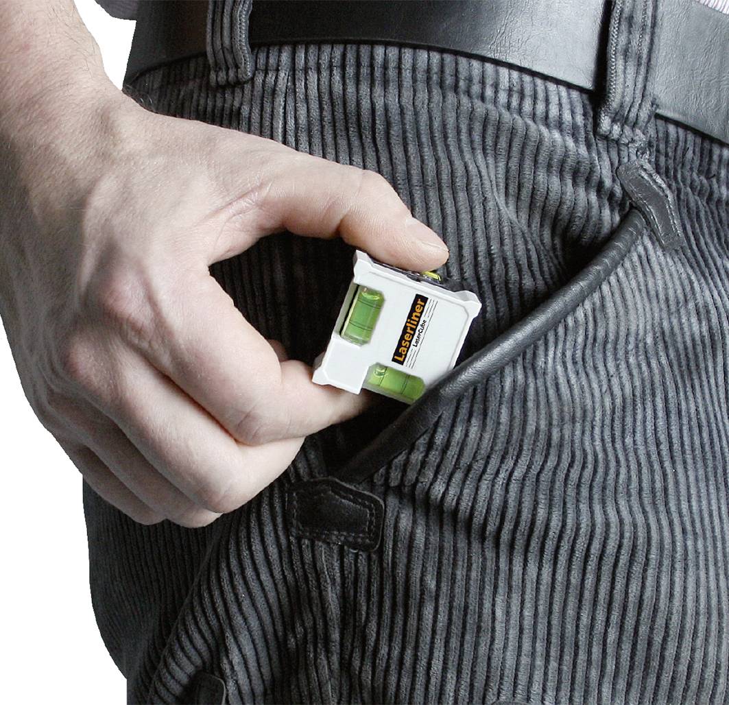 Une personne glisse un petit niveau à bulle dans sa poche de pantalon.