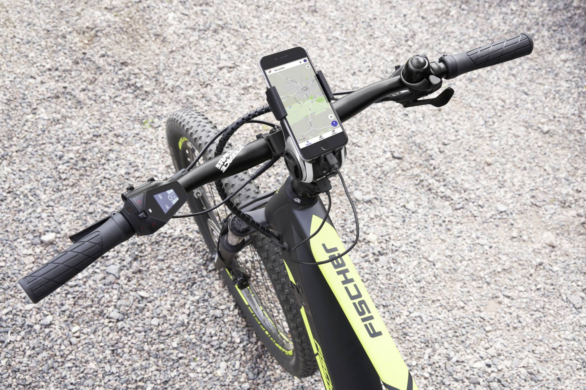 Un guidon de vélo électrique de la marque Fischer. Un smartphone avec une application de cartographie est fixé sur le guidon.