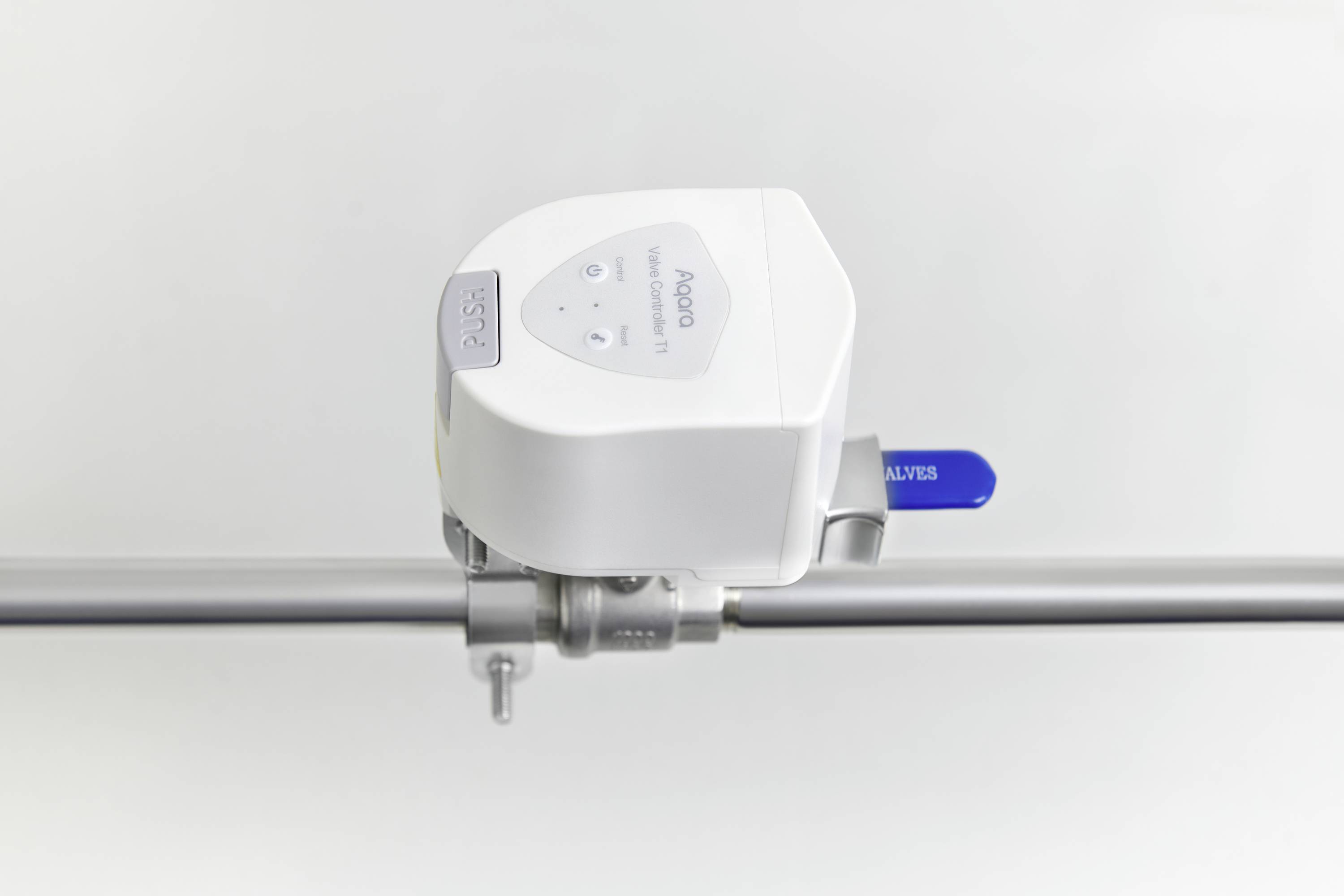 Une vanne automatisée sur un tuyau, avec un levier bleu et un boîtier blanc, portant l'étiquette 'BOSS'.