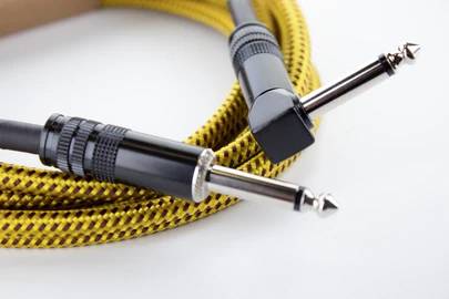 Un câble audio jaune tressé avec deux fiches jack 6,35 mm.