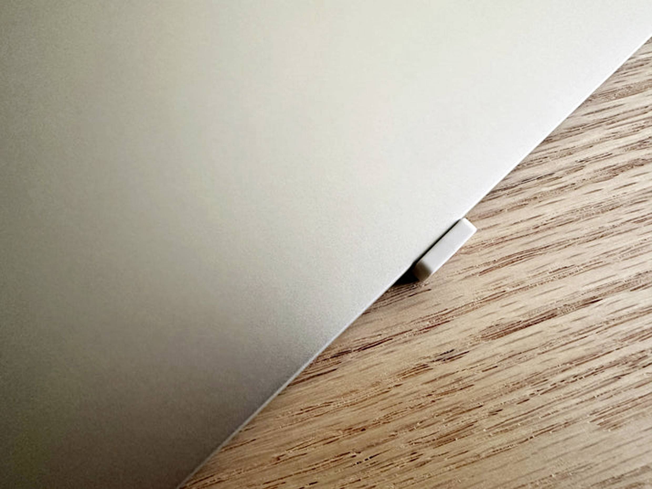 Ordinateur portable sur une table en bois, coin visible.