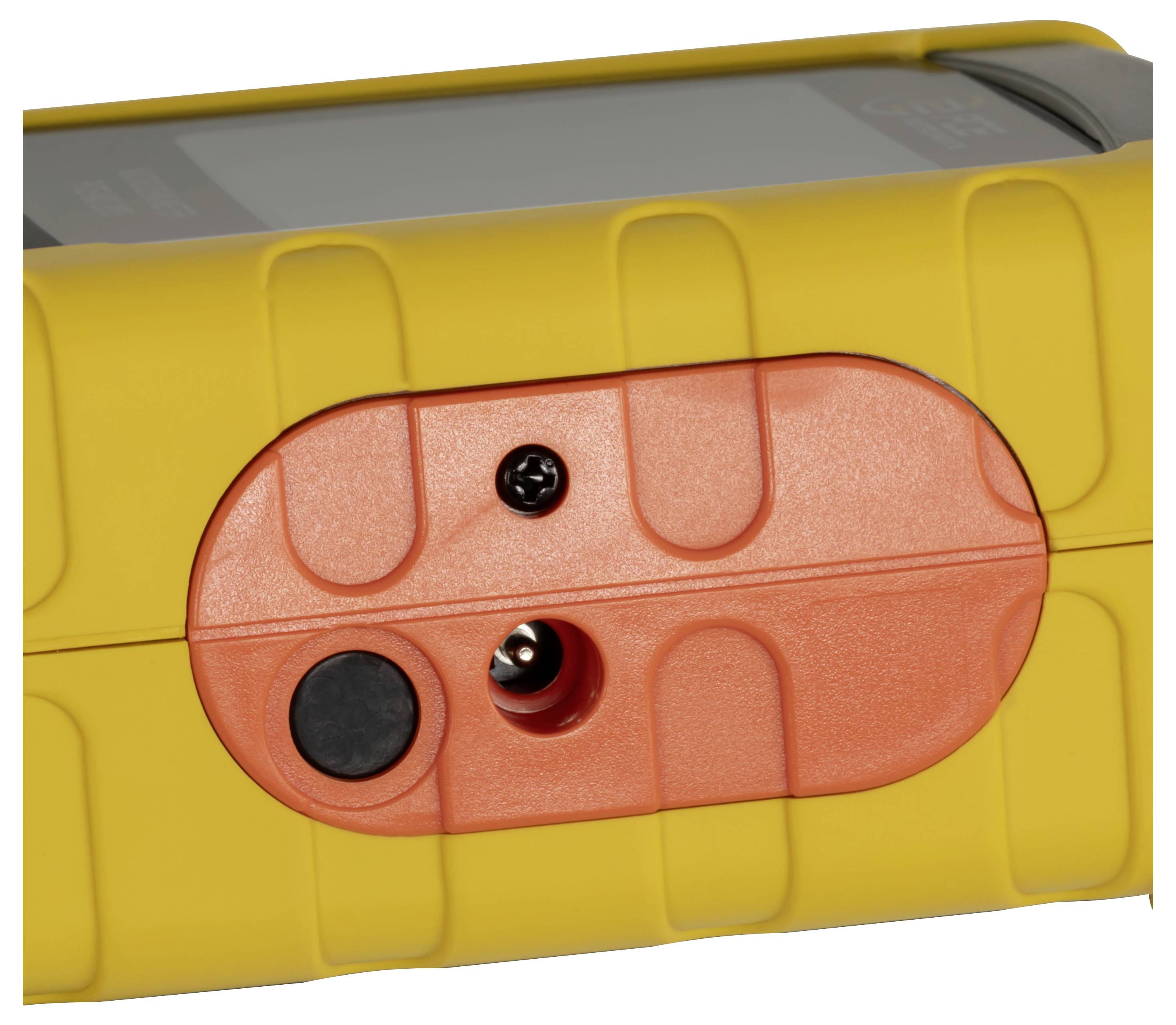 Gros plan d'un appareil jaune avec un panneau ovale orange, montrant un bouton noir et un port de connecteur ou de vis central.