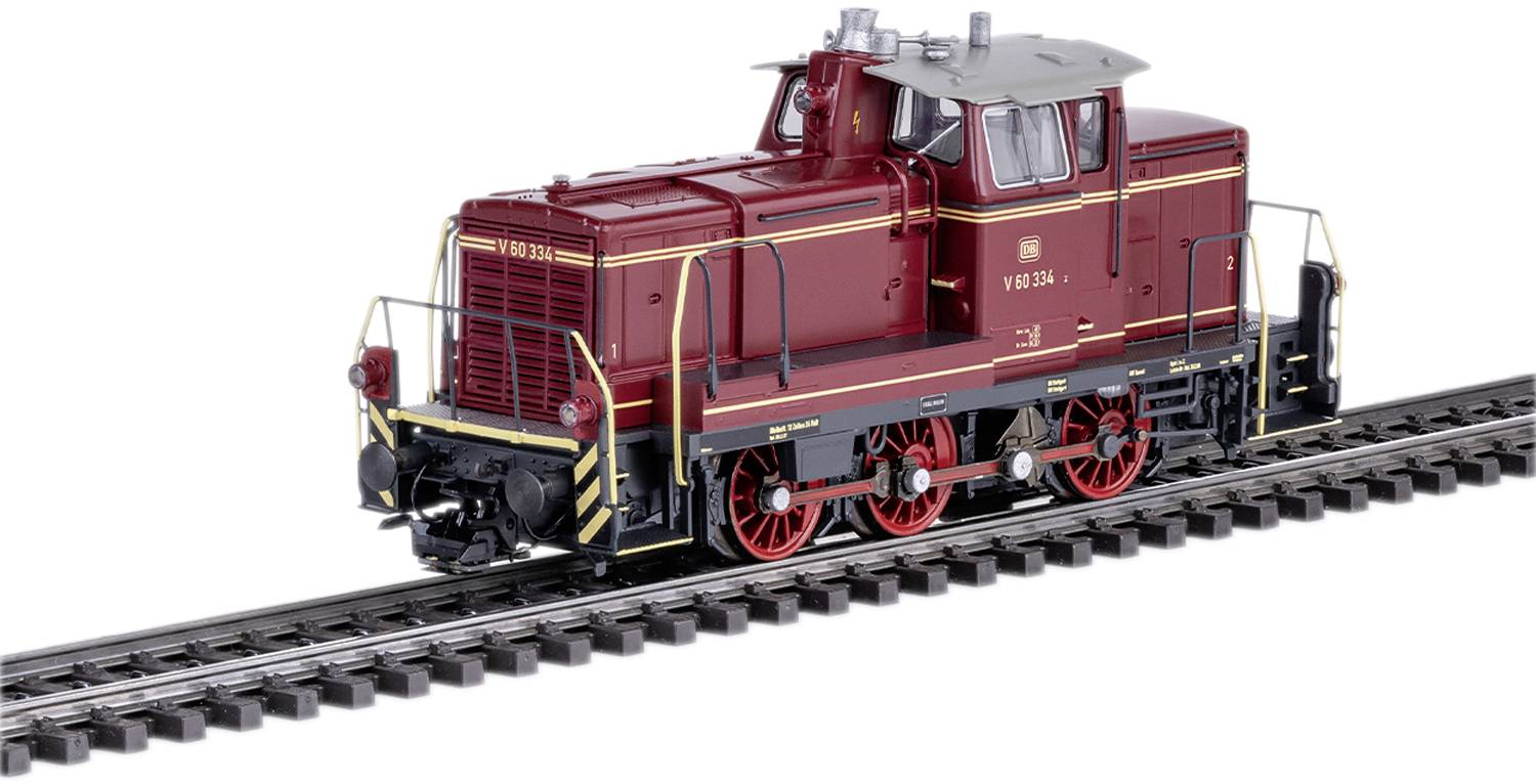 Une locomotive de train miniature rouge au design classique, posée sur un court segment de voie ferrée, avec des roues et des peintures détaillées.