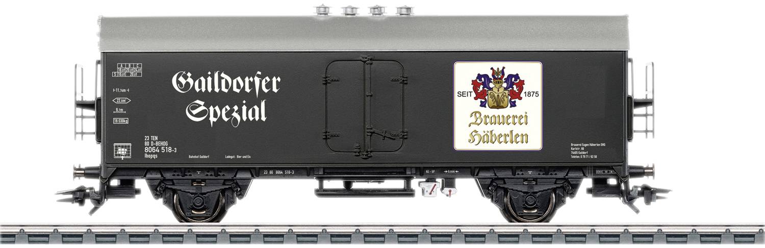 Un wagon de marchandises portant l'inscription 'Gaildorfer Spezial' et un blason de la brasserie Hoberglen, garé sur des rails.