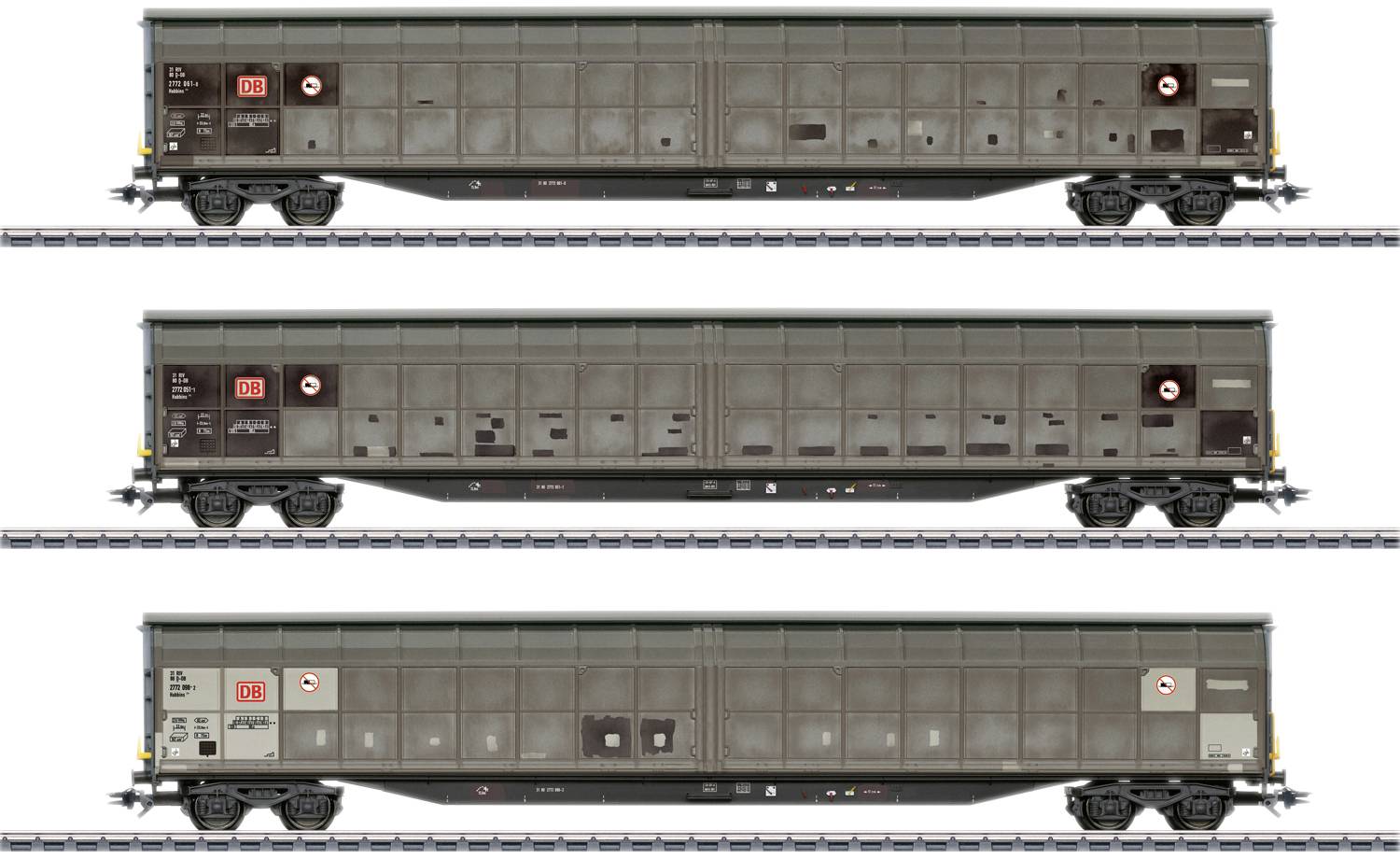 Trois wagons de marchandises sont stationnés sur des voies ferrées. Les wagons sont uniformes et portent des symboles techniques. Ils sont conçus pour le transport de fret.