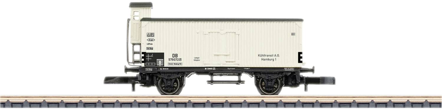 Modèle d'un wagon de marchandises sur une voie ferrée. Le wagon est de couleur crème avec des détails noirs et porte une inscription sur le côté.