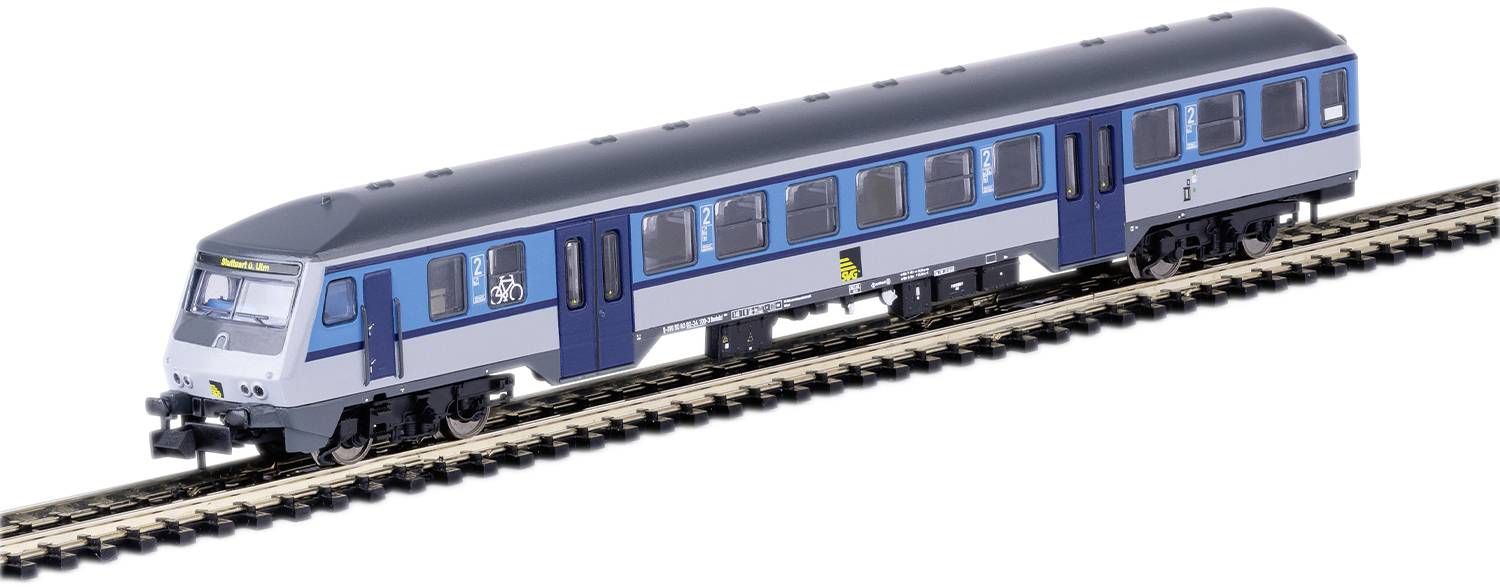 Un train de modèle bleu-gris sur des rails. Inscription 'Train régional' à l'avant. Des rangées de fenêtres sur les côtés affichent des symboles pour le transport de vélos.