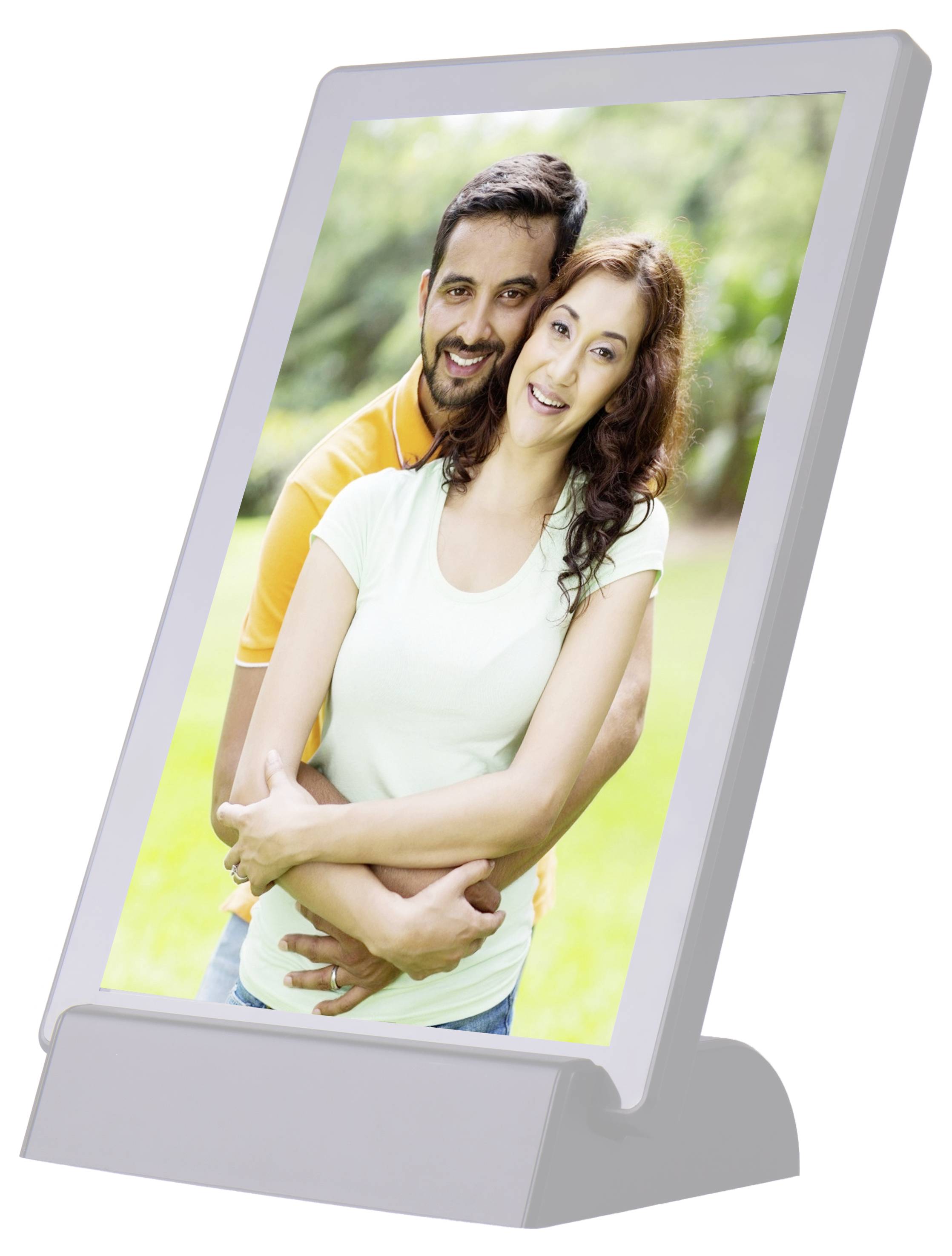 Un couple souriant se tient à l'extérieur. L'homme enlace la femme par derrière. L'arrière-plan montre une nature verdoyante floue.