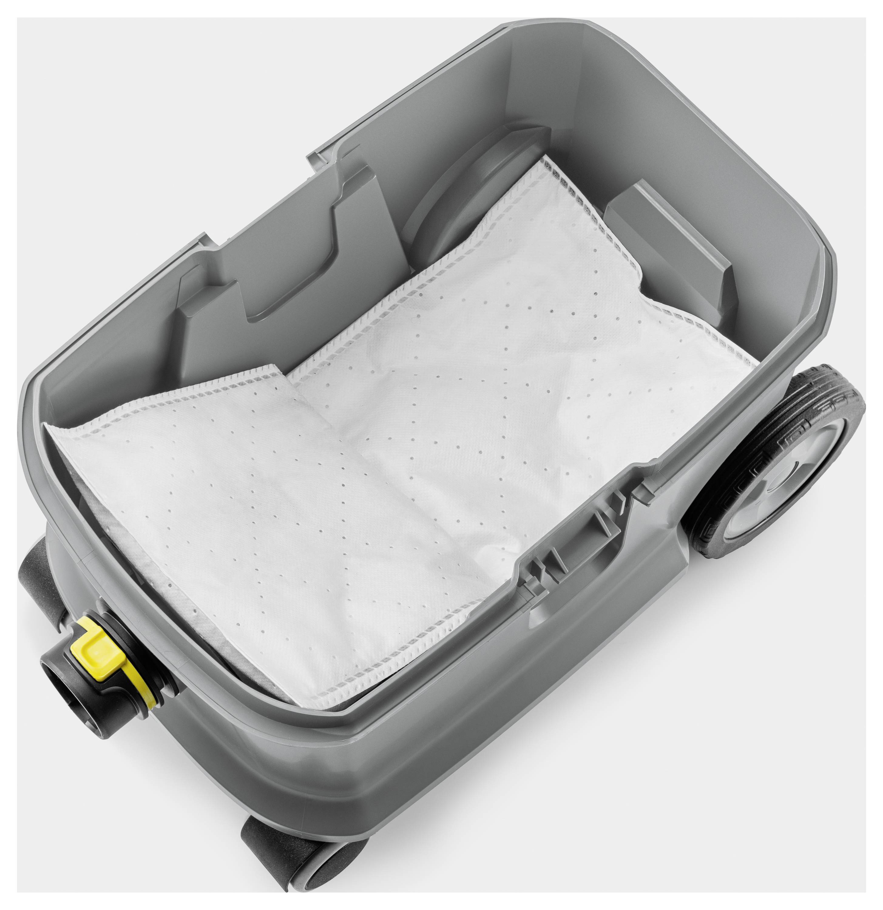 Un récipient gris d'un aspirateur avec un sac filtrant blanc inséré. Le récipient est en plastique et possède deux roues.