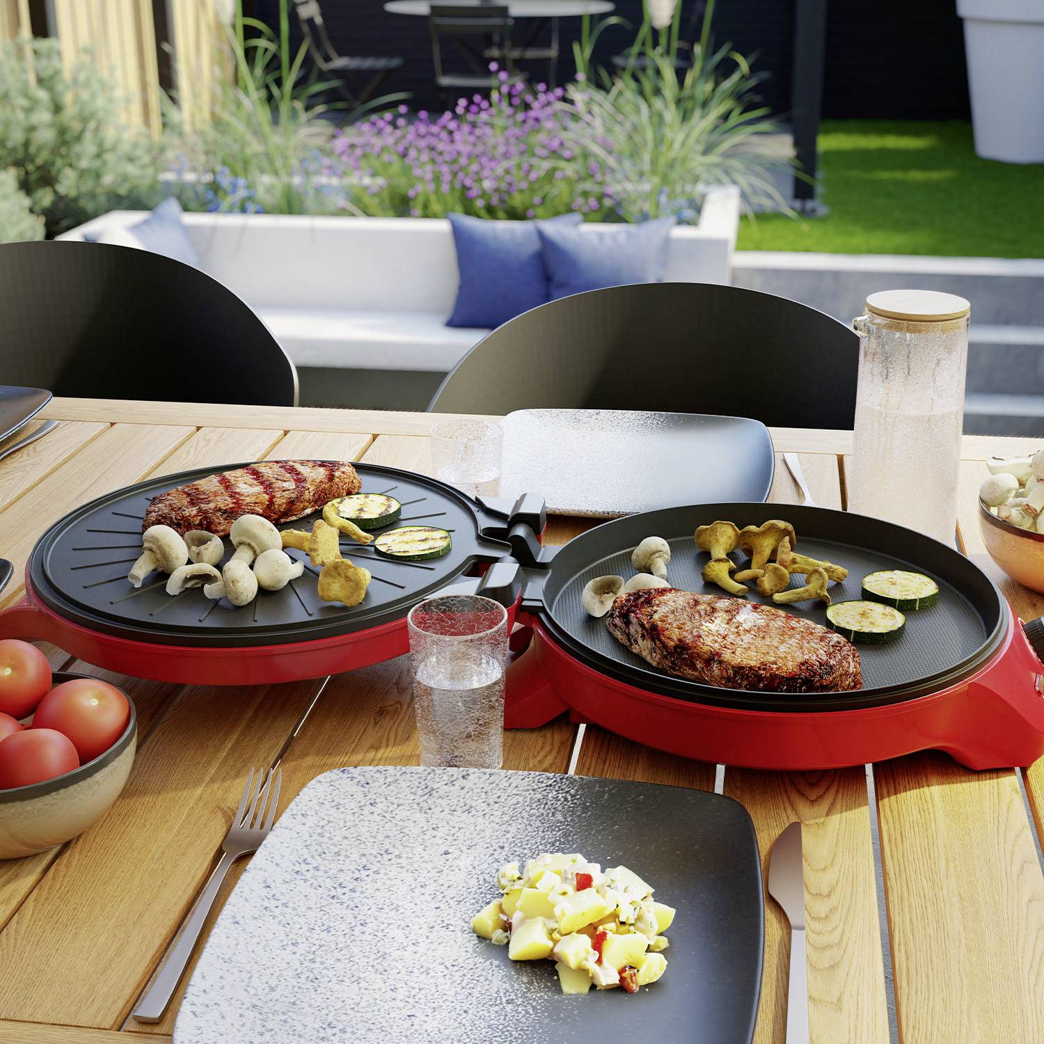Table en bois dans le jardin, dressée avec des assiettes, plaque de grill garnie de viande, légumes et champignons, tomates dans un bol, eau et salière.