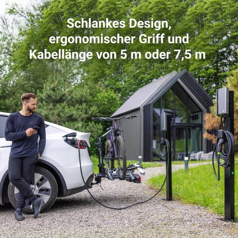 Un homme charge une voiture électrique à une borne de recharge en pleine nature, tenant un smartphone. Texte : 'Design élancé, poignée ergonomique et longueur de câble de 5 m ou 7,5 m'. À l'arrière-plan, une maison moderne.
