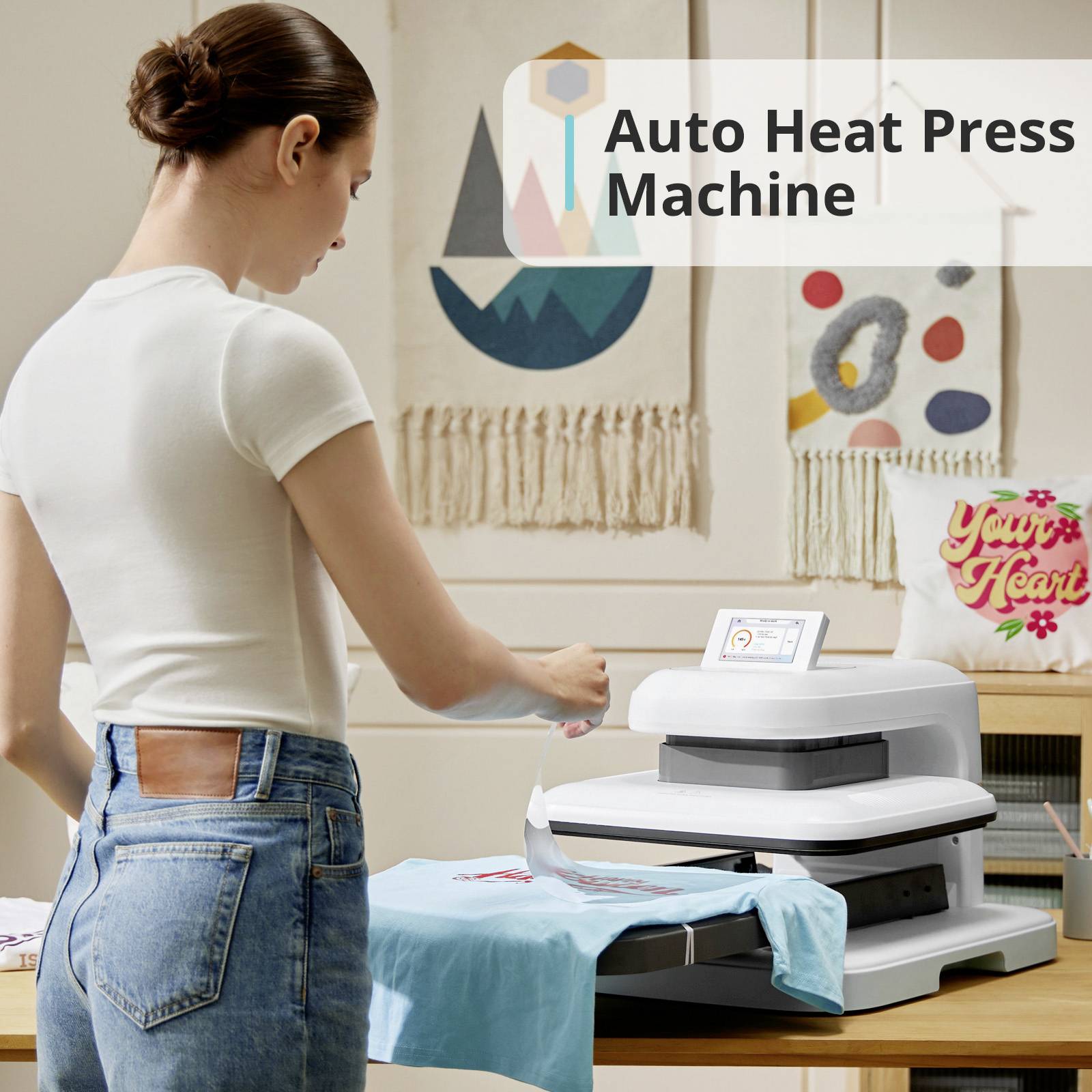 Une femme utilise une presse de transfert automatique pour imprimer un t-shirt. En arrière-plan, un écriteau indique : « Machine de transfert thermique automatique ».