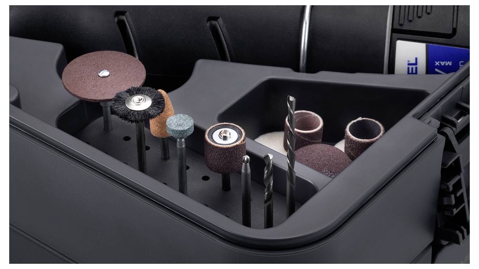 Une boîte à outils noire présente divers outils de meulage et de perçage alignés dans des compartiments, prêts à être utilisés.