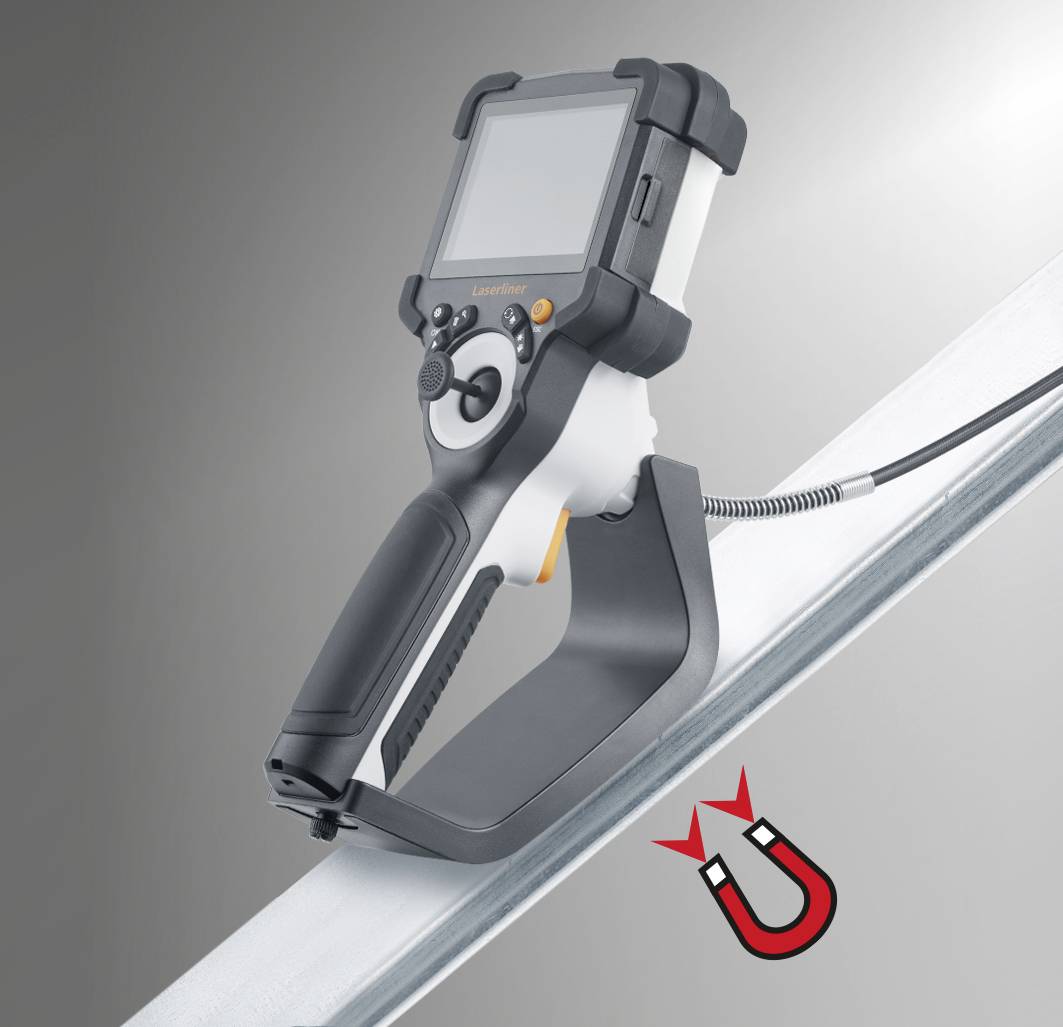 Appareil portable avec un écran gris, tenu près d'une pièce métallique. Un symbole d'aimant en bas à droite indique une fonction magnétique.
