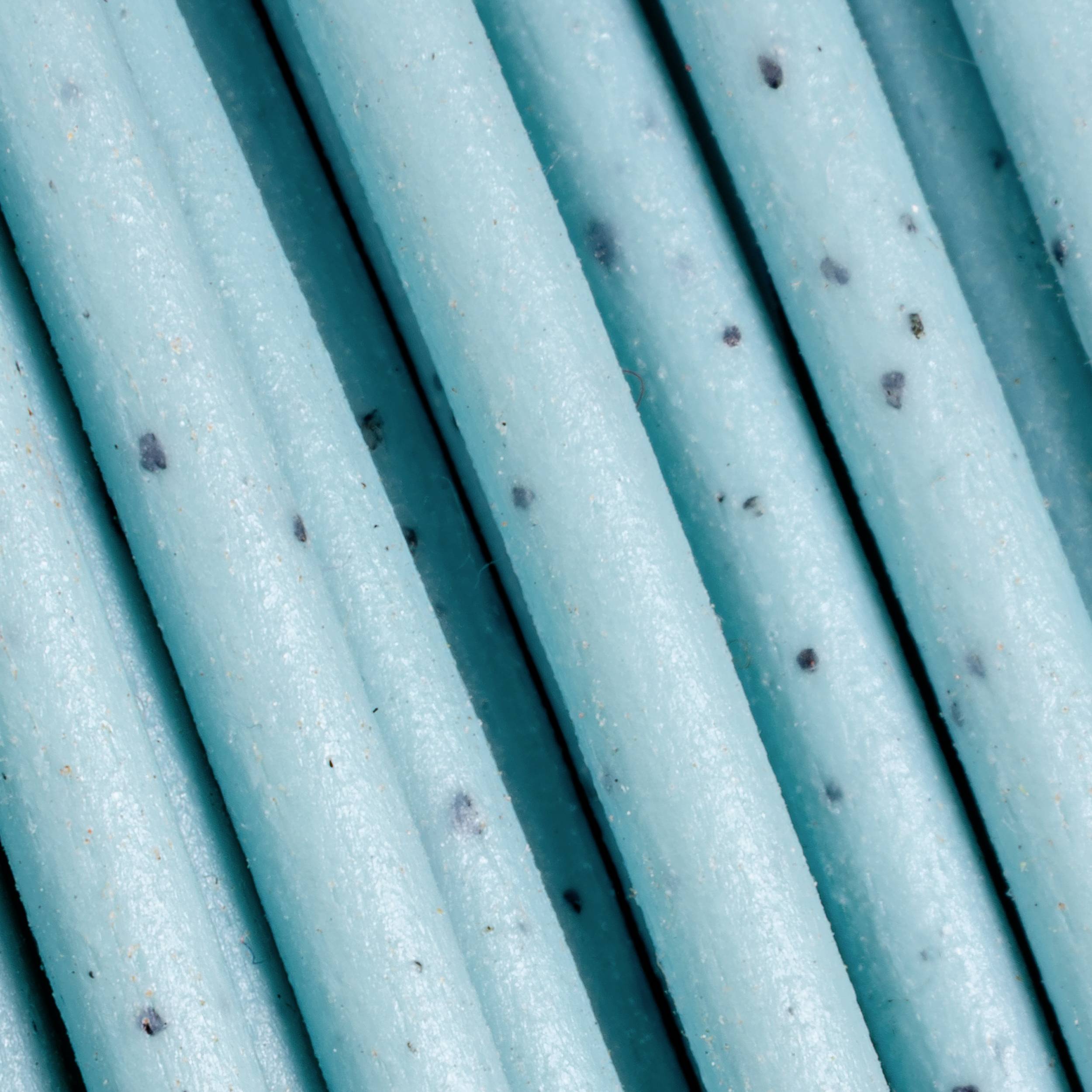 Plusieurs pailles bleues adjacentes avec des points noirs qui forment un motif sur la surface.