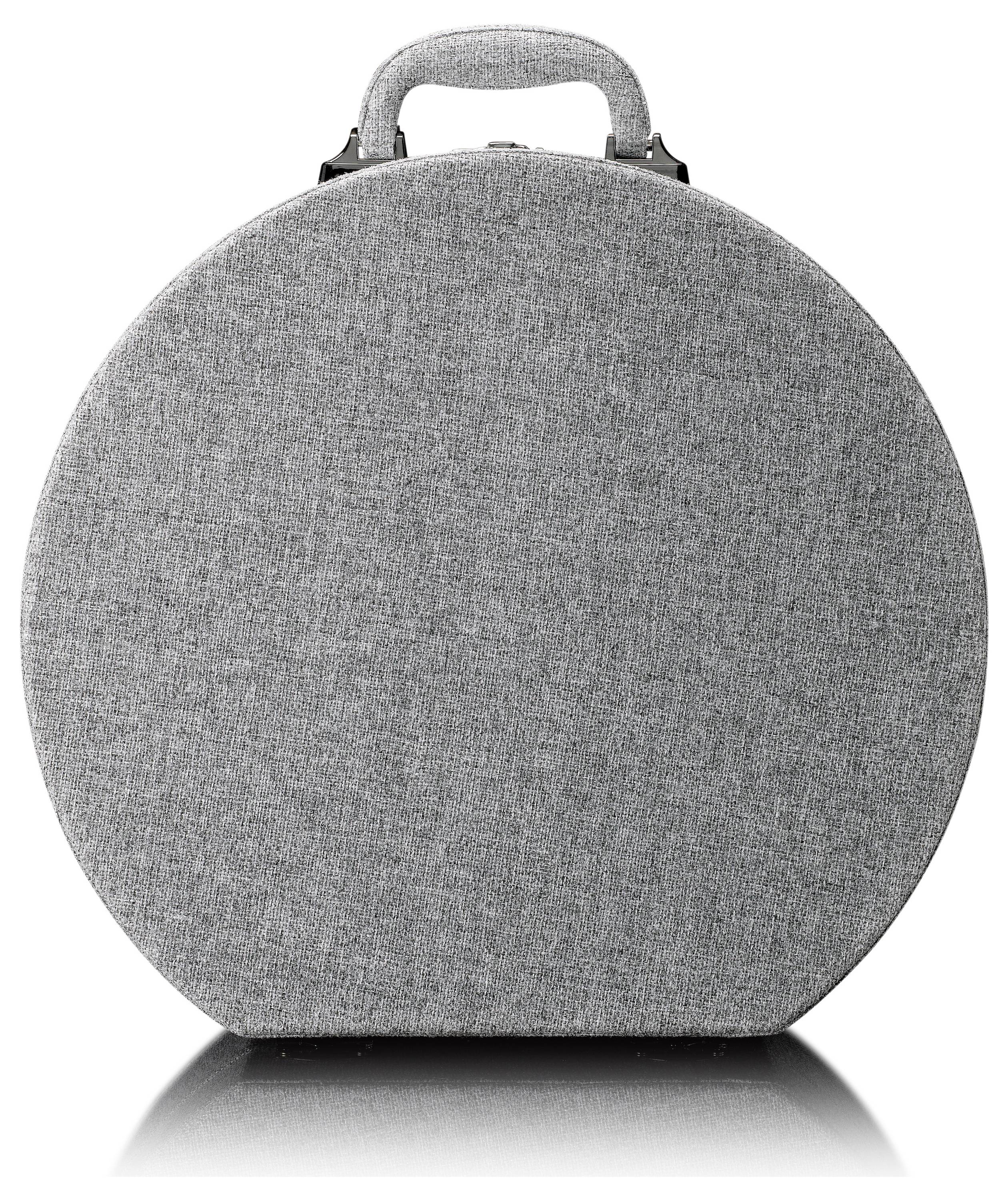 Coffret de rasage rond gris avec poignée de transport, posé sur une surface réfléchissante.
