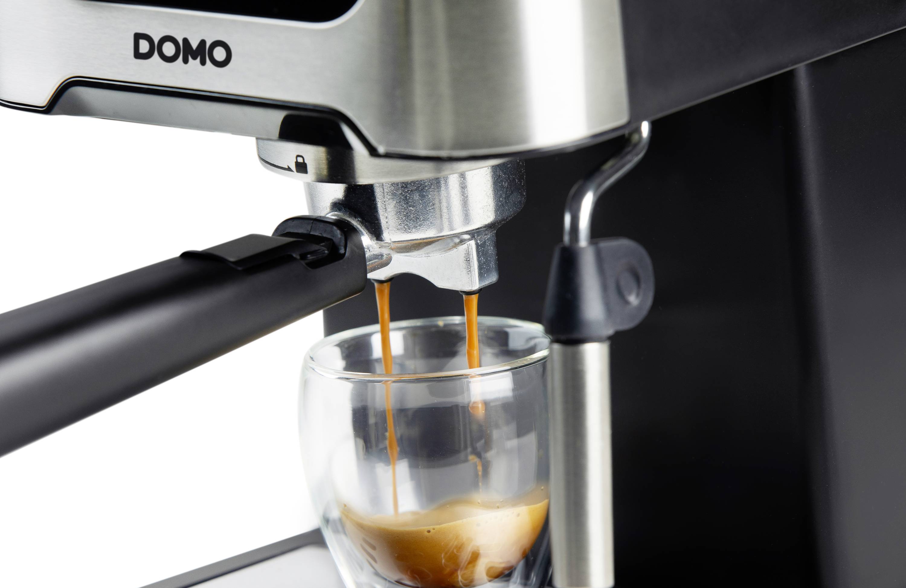 Machine à espresso qui prépare un café dans un verre. De la vapeur s'échappe pendant que la machine fonctionne.