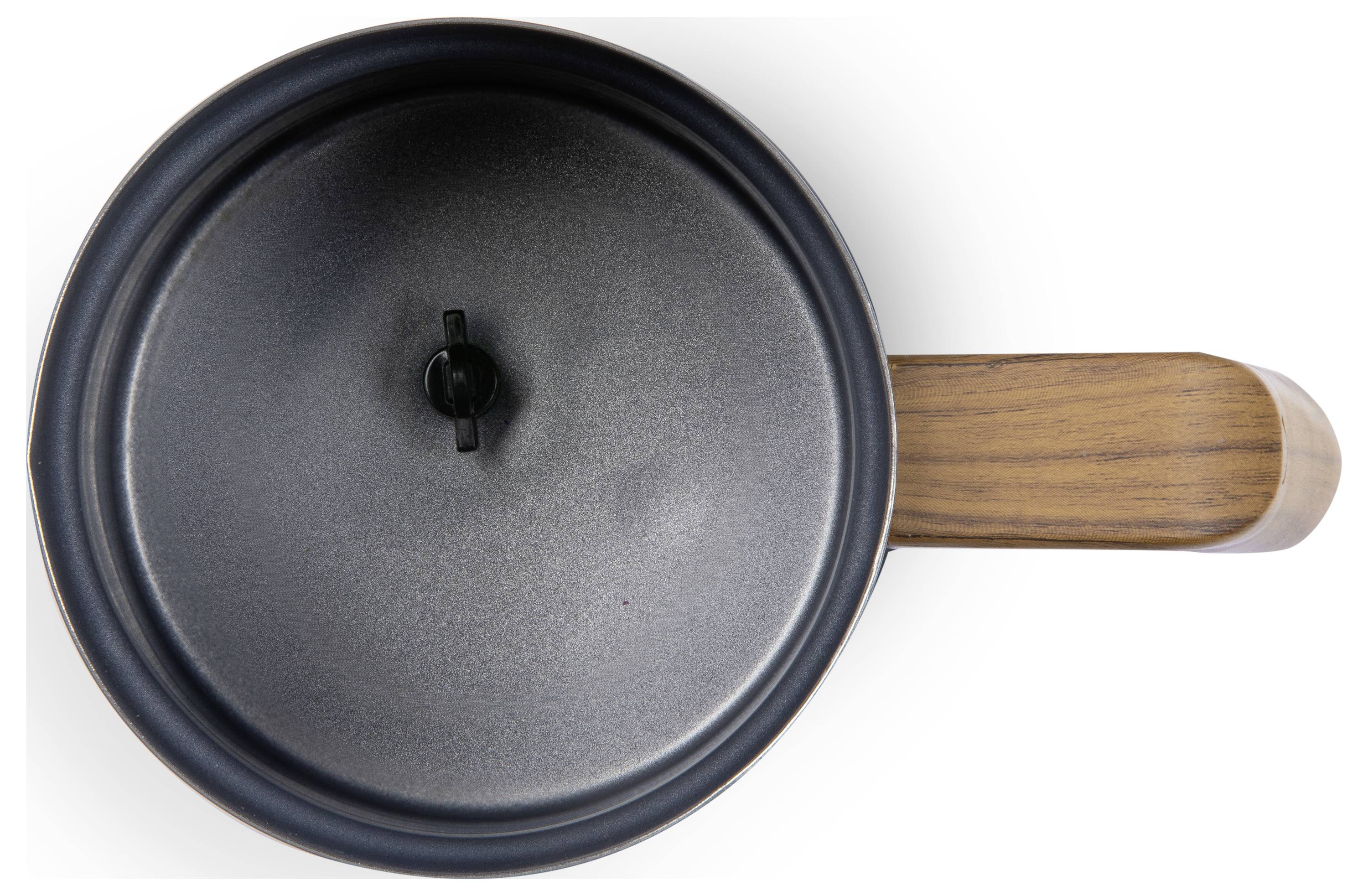 Vue de dessus d'une casserole noire avec une poignée en bois et un couvercle. La casserole est posée sur une surface blanche.