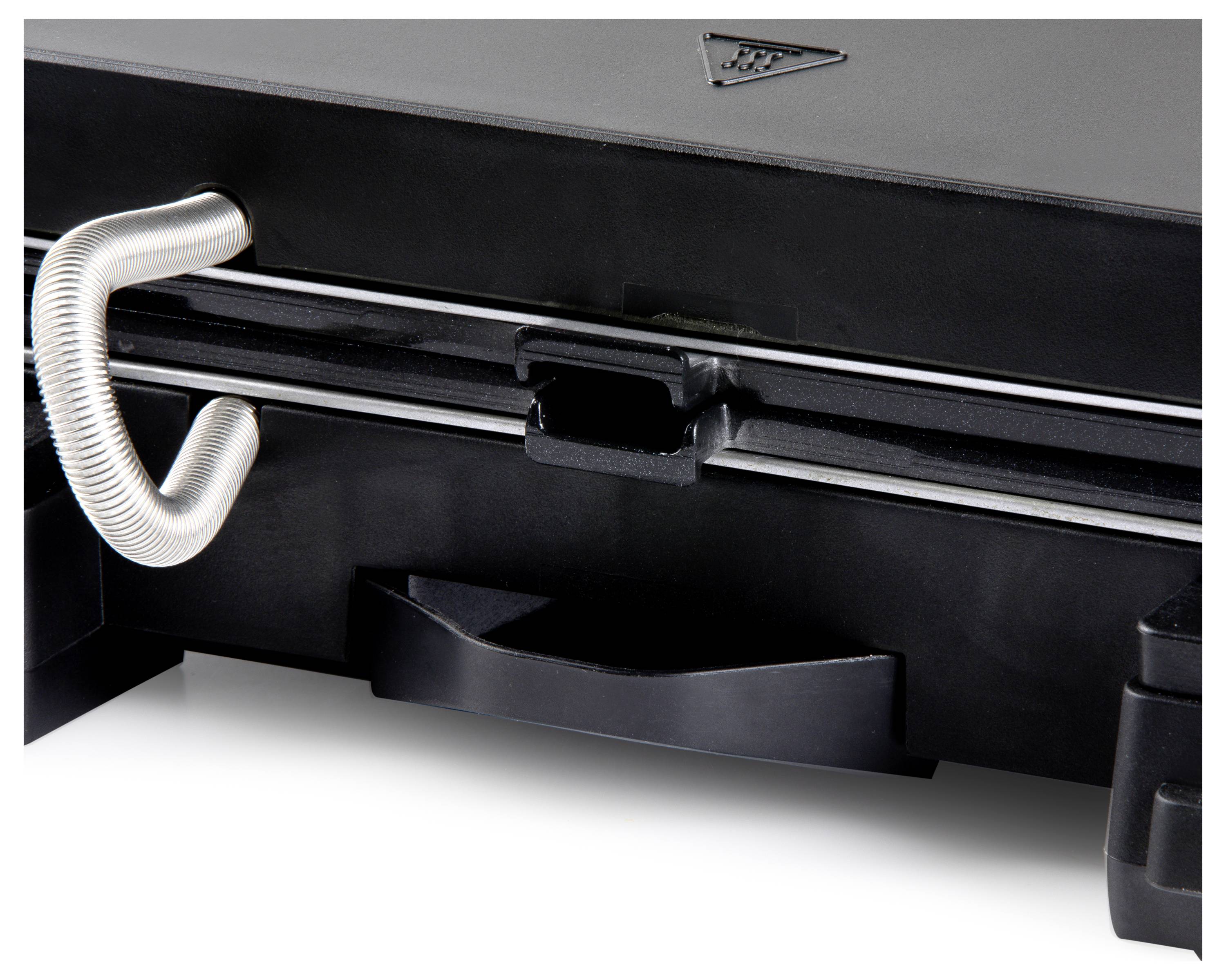 Un gril de contact noir avec une poignée en métal et un symbole d'avertissement triangulaire sur le dessus est visible.