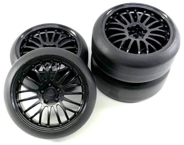 Quatre roues de voiture noires avec des jantes brillantes, deux debout et deux à plat. Adaptées aux sports mécaniques sur surfaces lisses.