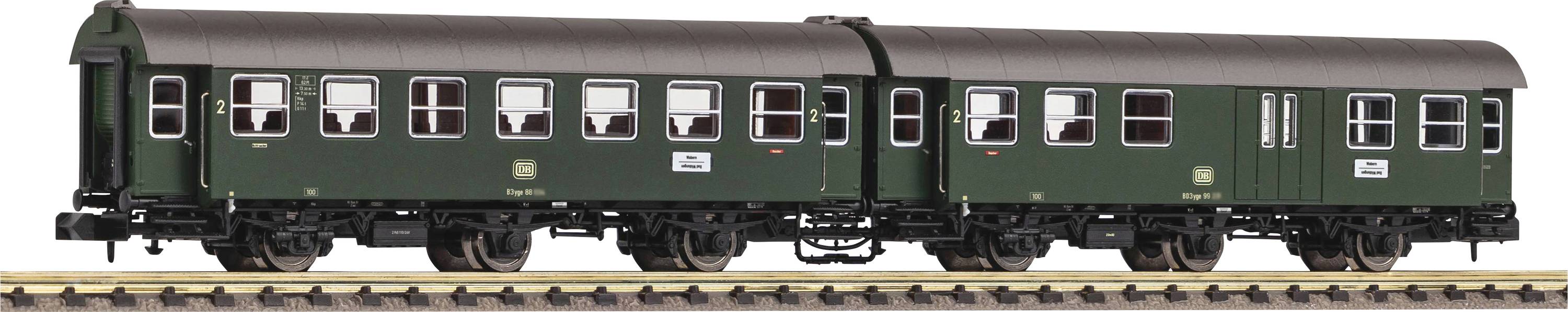 Deux wagons ferroviaires verts sur des rails, vue latérale, avec plusieurs fenêtres et des inscriptions sur les portes.