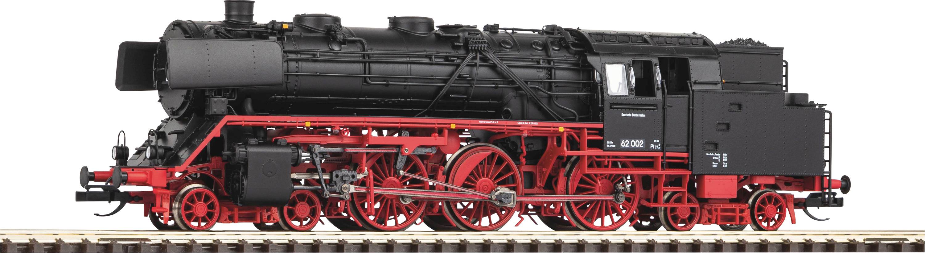 Locomotive de train miniature en noir et rouge sur une voie ferrée, montrant des roues et une structure de chaudière détaillées.
