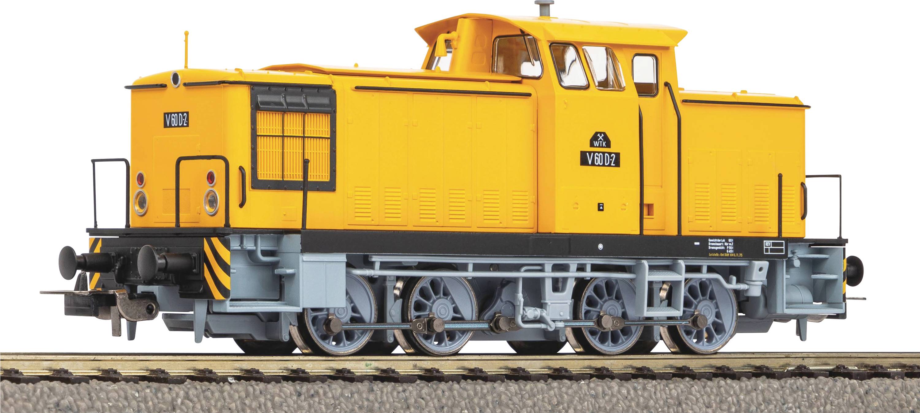 Modèle de locomotive jouet jaune sur un tronçon de rail. La locomotive présente des bandes noires distinctives et des supports de roues détaillés.