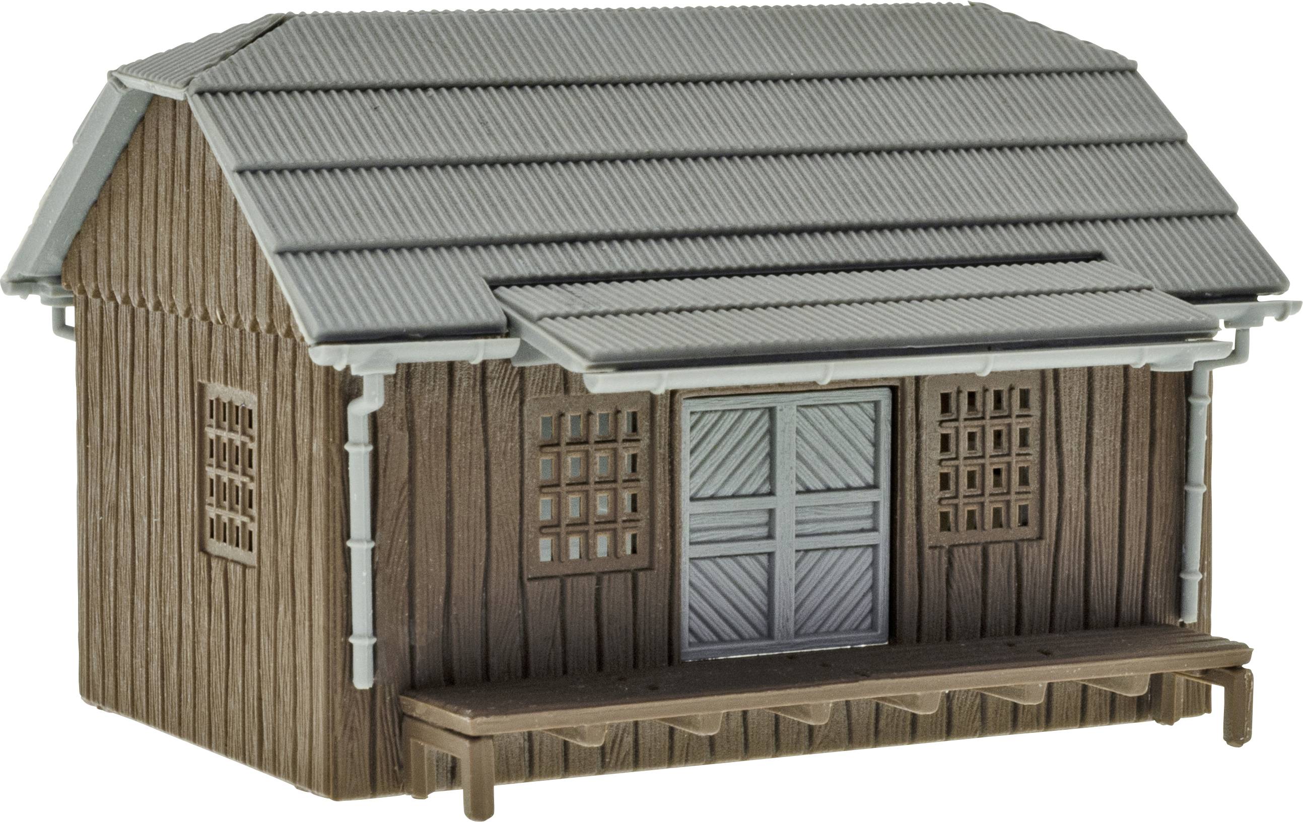 Bâtiment en bois avec un toit en tôle ondulée grise, double porte et petites fenêtres. Style rustique, probablement un entrepôt ou une cabane.