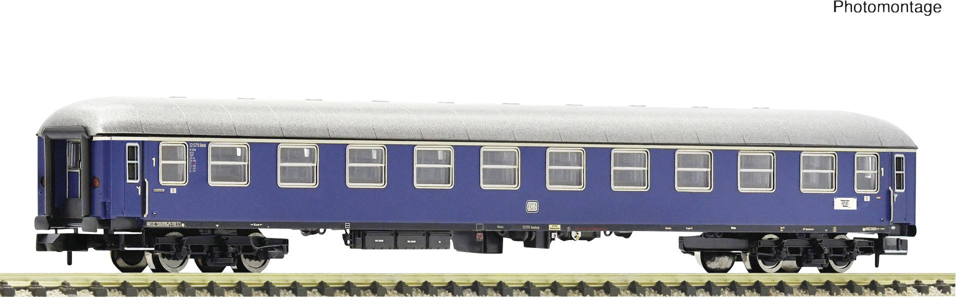 Un wagon de train miniature bleu sur une voie ferrée. Le wagon possède plusieurs fenêtres rectangulaires et un bord de toit argenté.