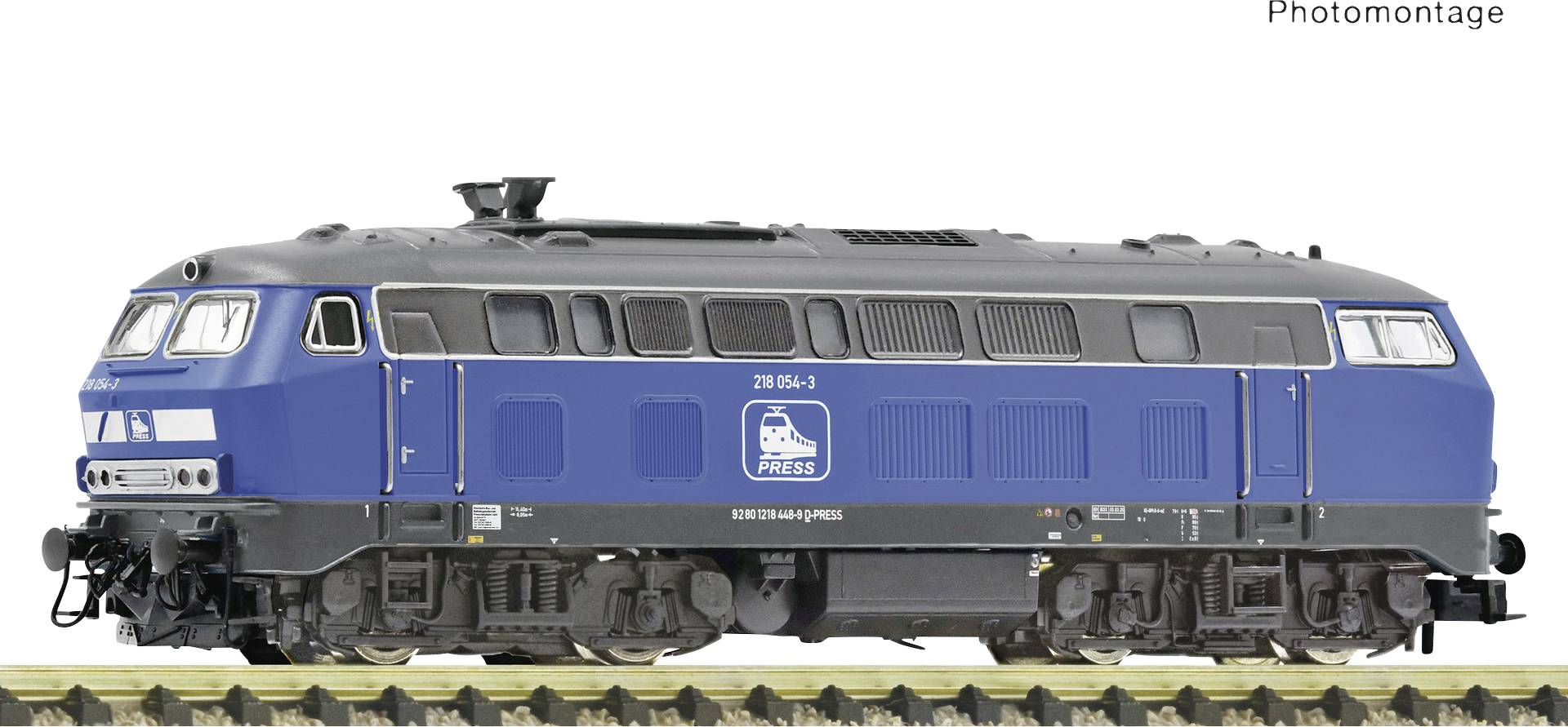 Locomotive de train miniature bleue sur une section de voie ferrée, vue de côté. Le véhicule est étiqueté 'PRESS'.