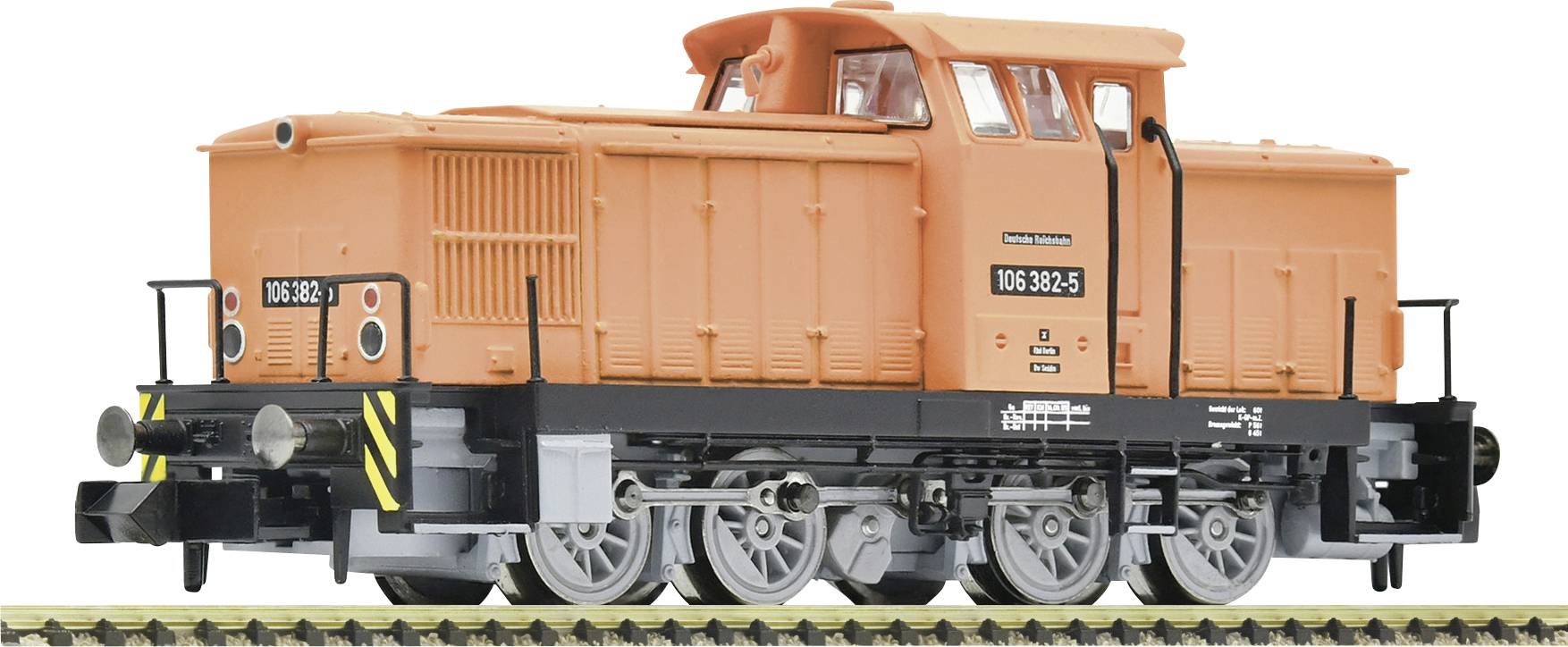 Un modèle orange d'une locomotive diesel est posé sur une voie ferrée. La locomotive porte l'inscription '106 382-5'.