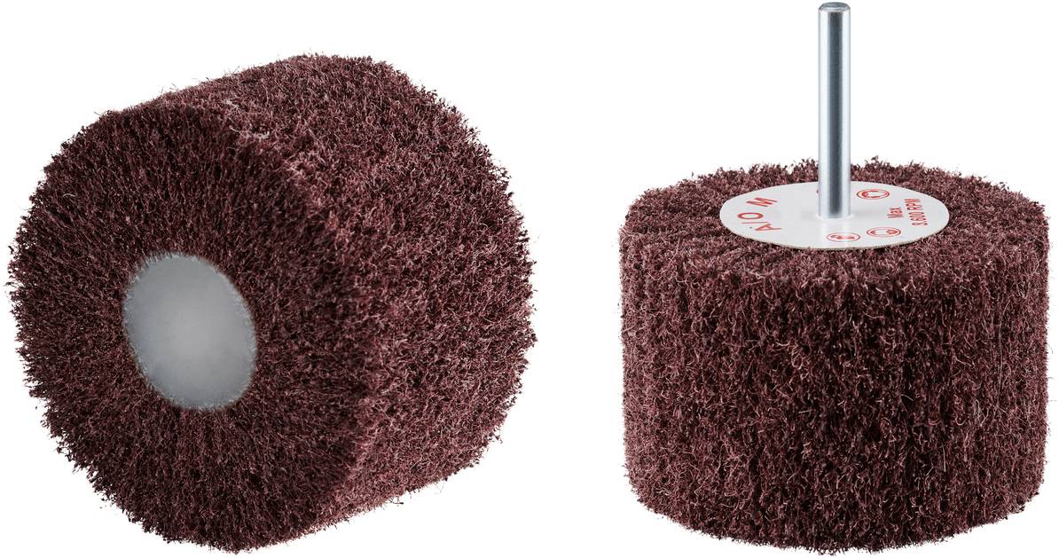 Deux meules, l'une couchée, l'autre debout. Toutes deux ont une surface rugueuse, brune, et une tige métallique en leur centre.