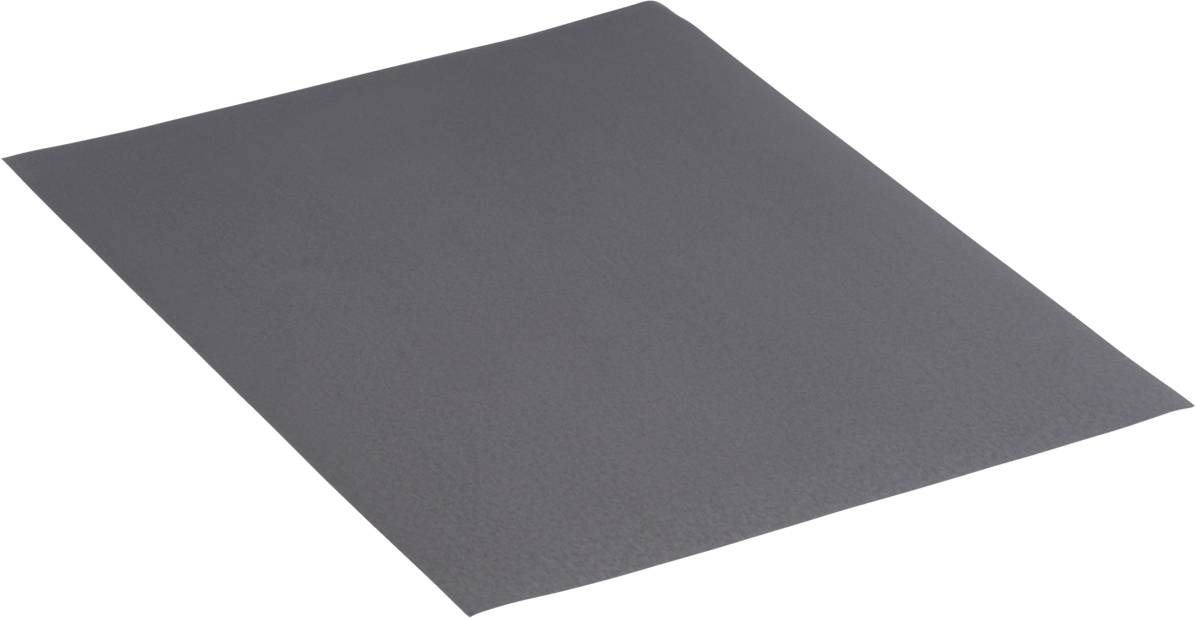 Un morceau de papier de verre rectangulaire à la surface sombre et rugueuse, posé à plat sur une surface.