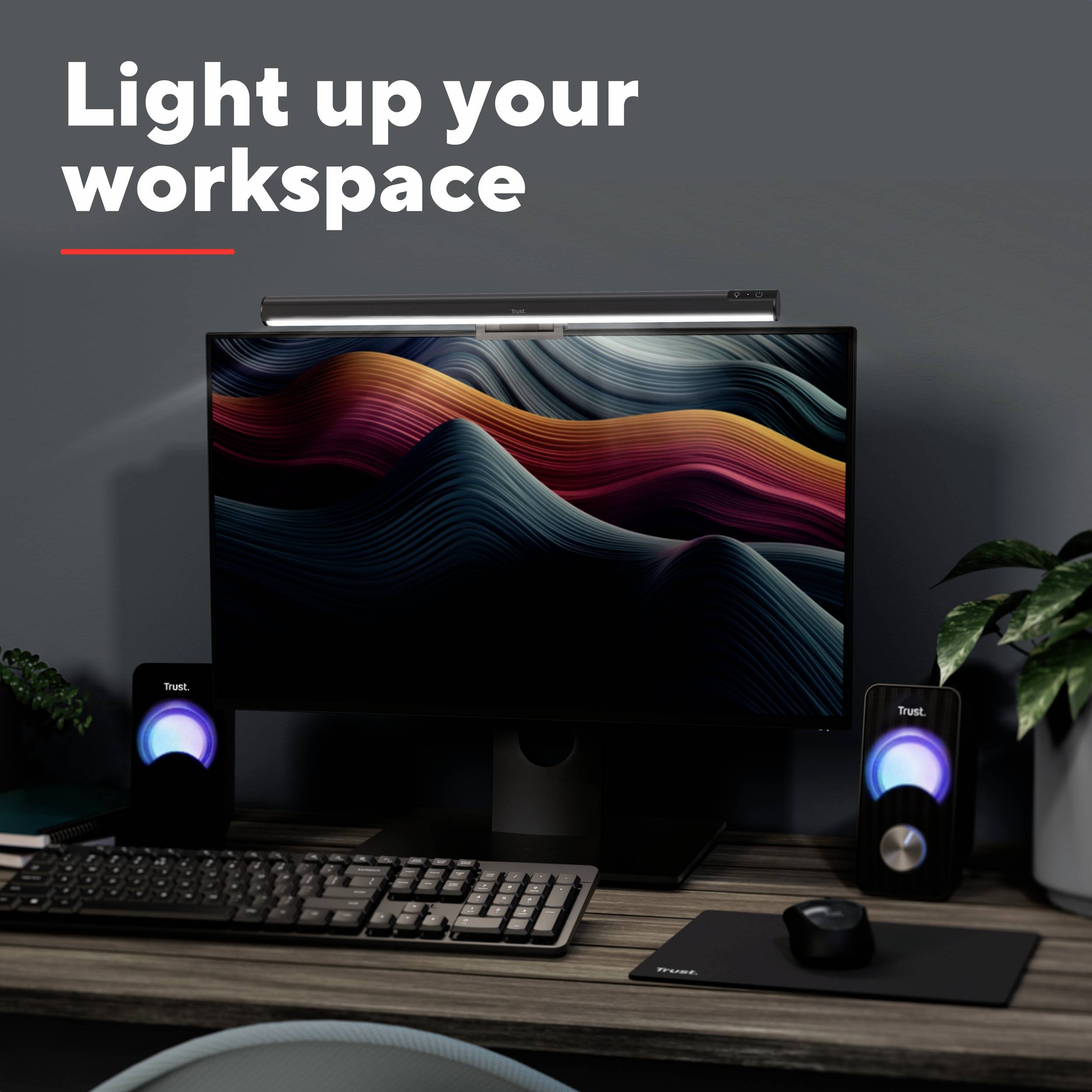 Un bureau élégamment éclairé avec un moniteur moderne, des vagues de couleurs sur l'écran et des enceintes décoratives.