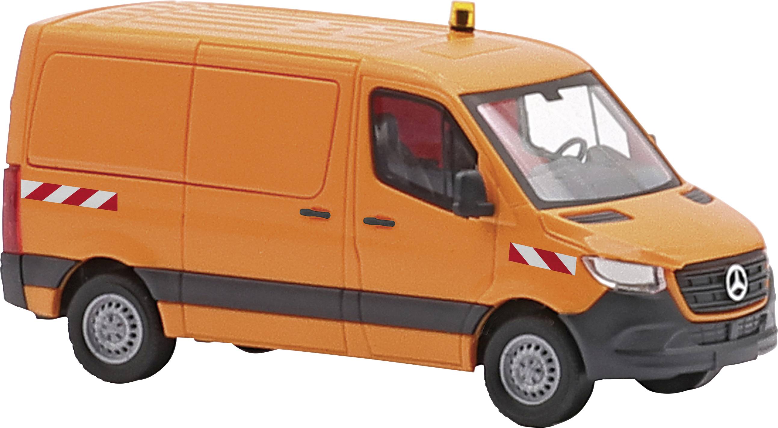 Fourgonnette orange Mercedes-Benz, modèle Sprinter, avec un gyrophare jaune sur le toit et des bandes réfléchissantes.