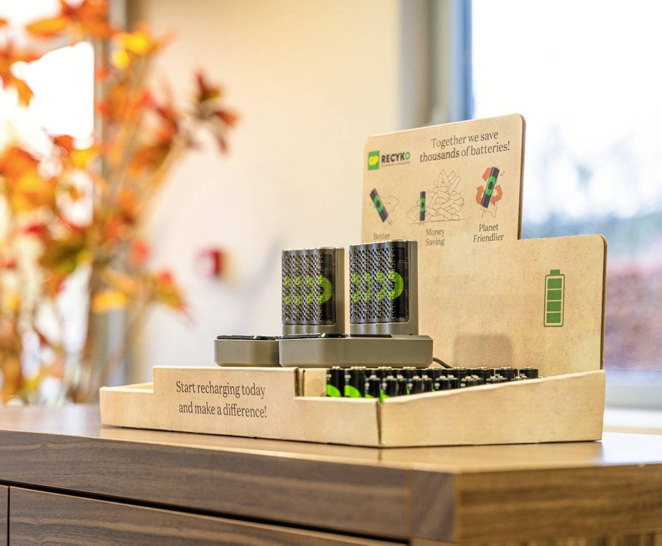 Un affichage de station de recharge avec des batteries rechargeables et des panneaux mettant en évidence l'avantage environnemental du rechargement.