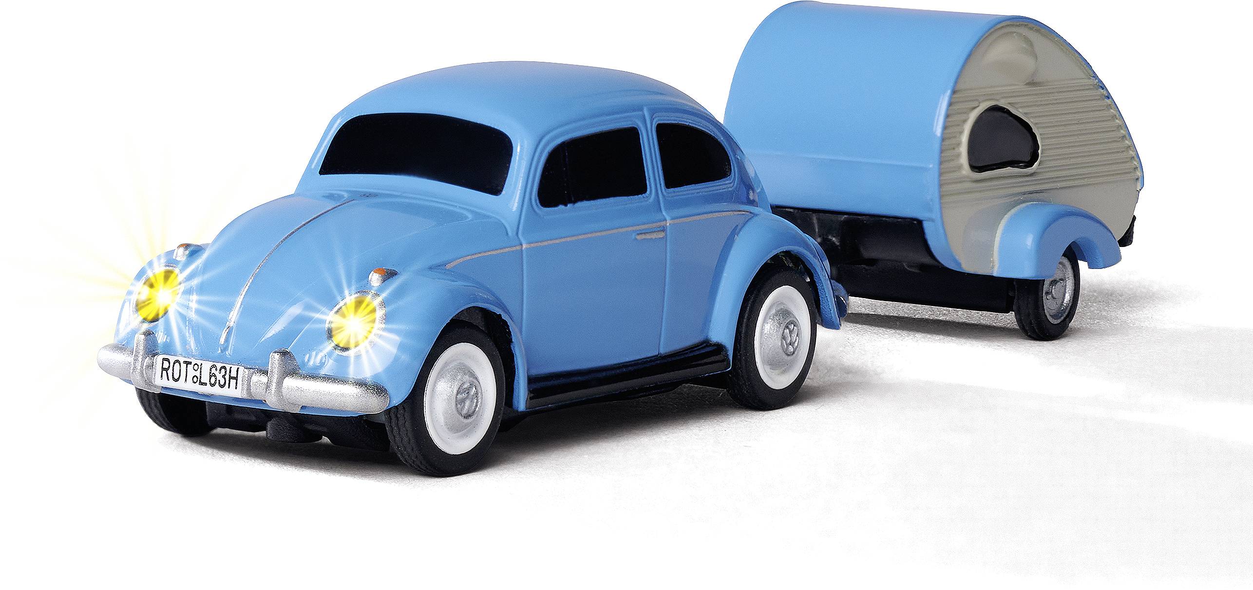 Une petite voiture de collection bleue dans un style rétro, avec des phares brillants, tractant une caravane miniature. Elle symbolise les voyages et l'aventure.