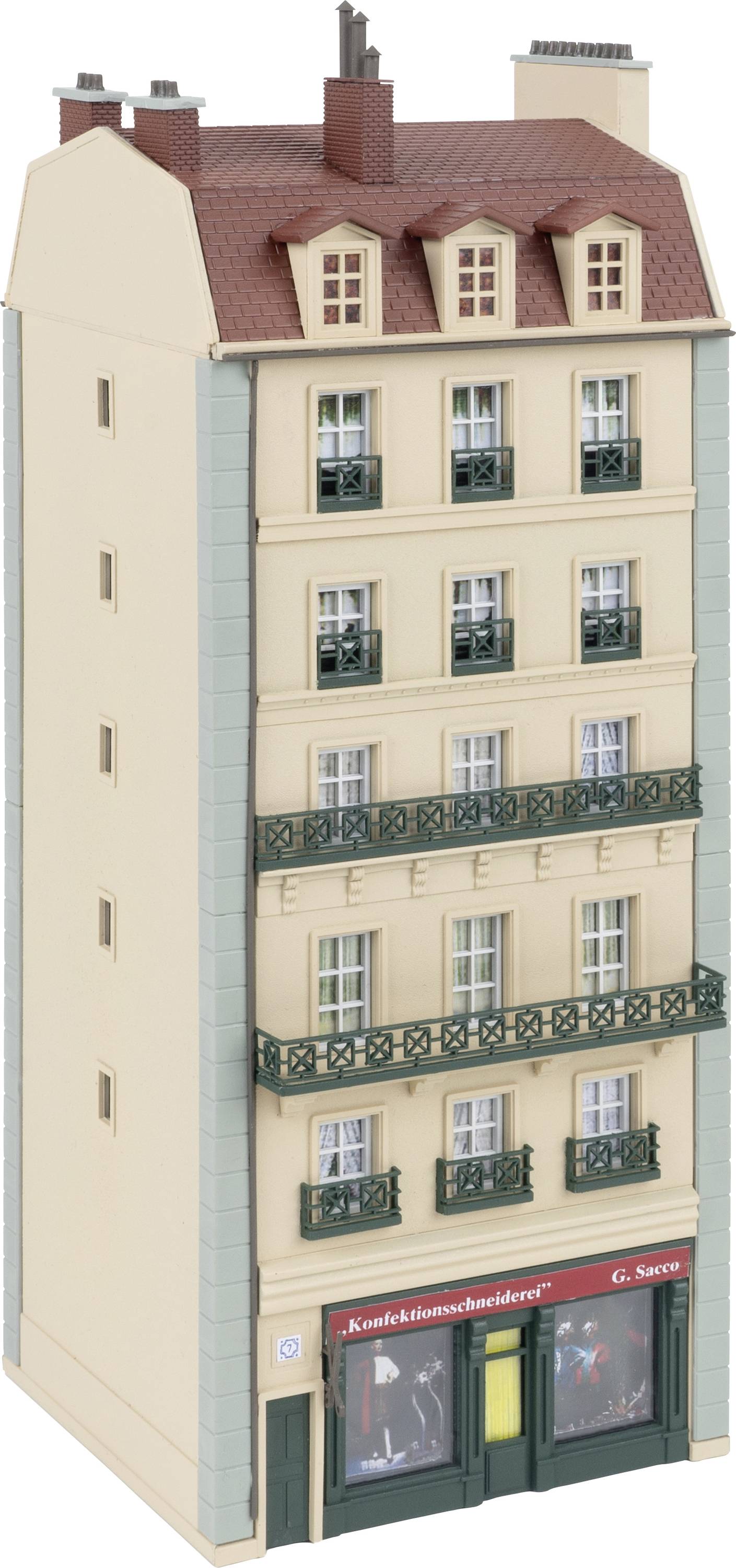 Un modèle d'une maison de ville de cinq étages avec six balcons verts marquants et un magasin au rez-de-chaussée portant l'inscription 'Tailleur de confection'.