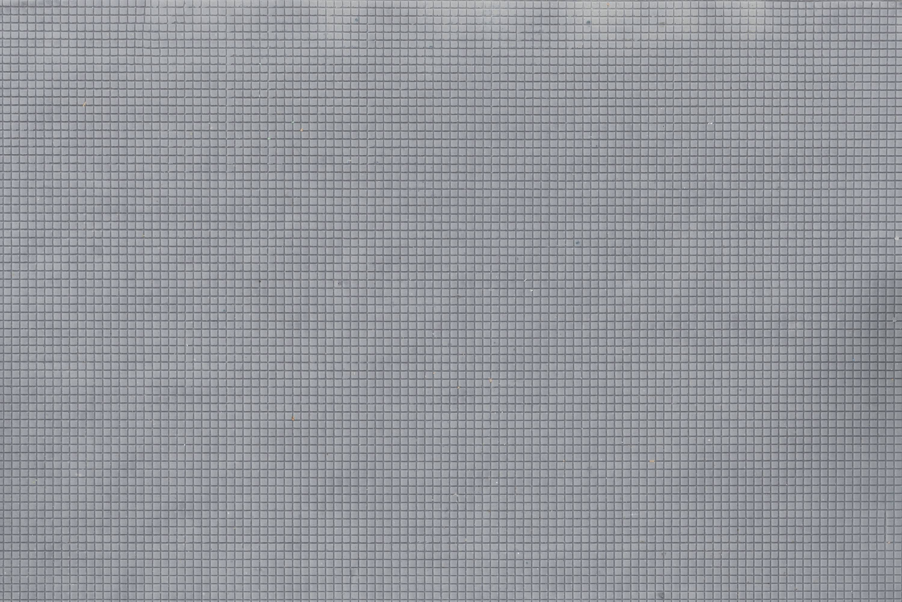 Surface de fond bleue, recouverte d'un fin motif quadrillé. Il n'y a pas de motifs centraux ou de détails spécifiques.