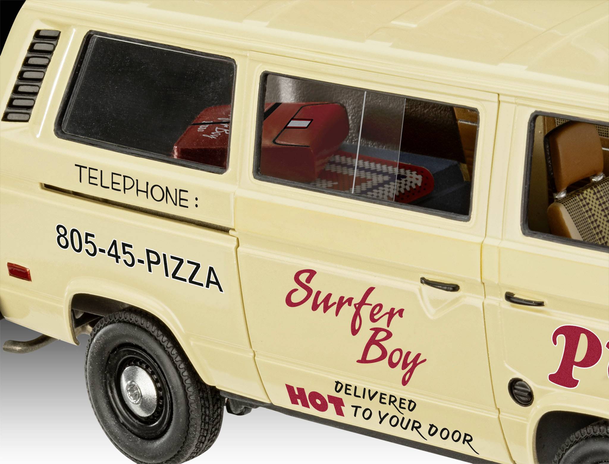 Un fourgon jaune portant l'inscription 'Surfer Boy Pizza' et '805-45-PIZZA'. Une table et des sièges sont visibles à travers la fenêtre.