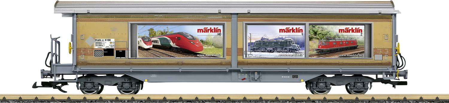 Wagon de marchandises avec publicité Märklin, montrant des images de trains rouges et bleus. Posé sur un rail. Publicité pour les trains miniatures.