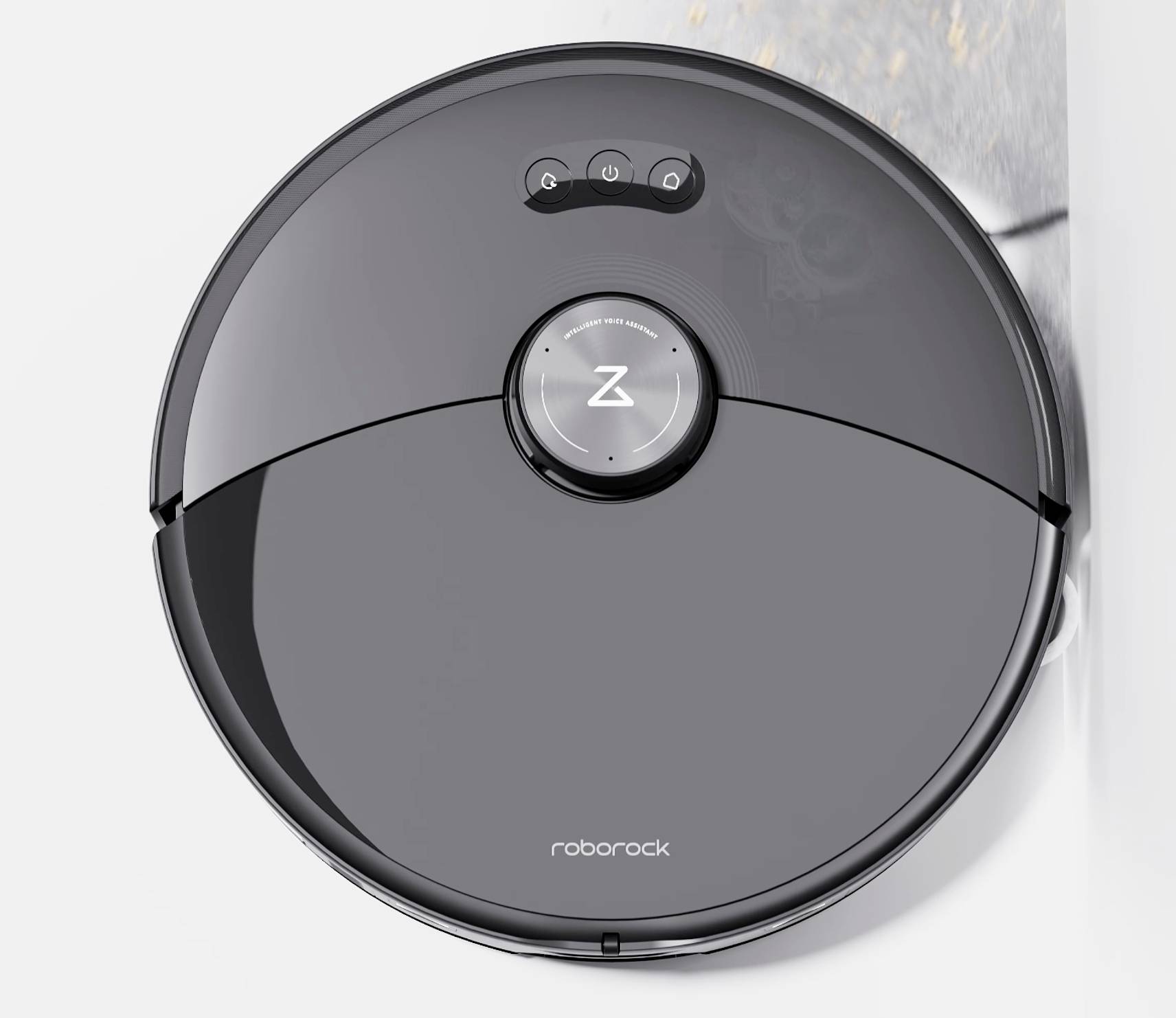 Un robot aspirateur noir nettoie le sol le long d'un mur.