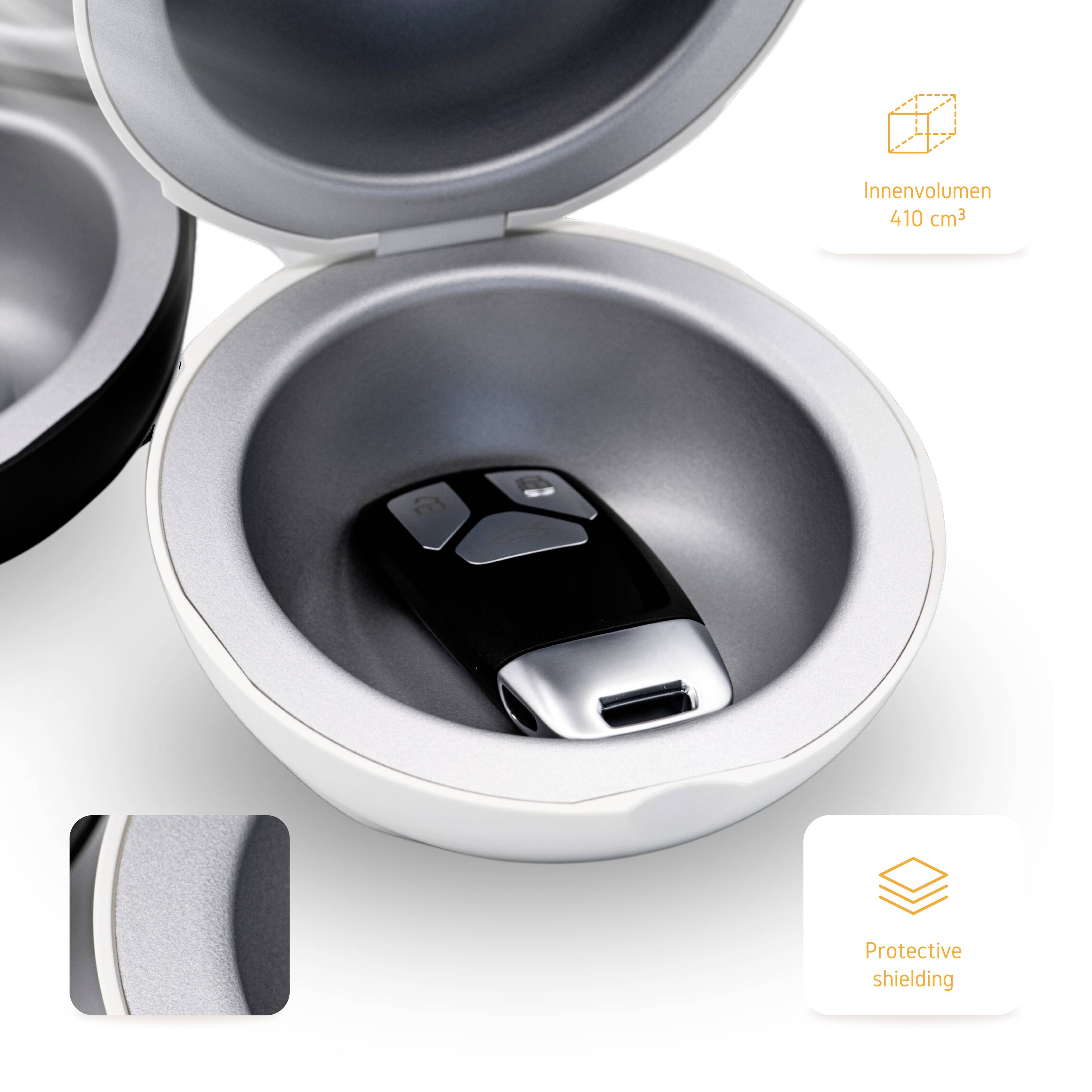 Une boîte de protection circulaire ouverte contenant une clé de voiture à l'intérieur. Les textes 'Volume intérieur 410 cm³' et 'Protection blindée' sont visibles.