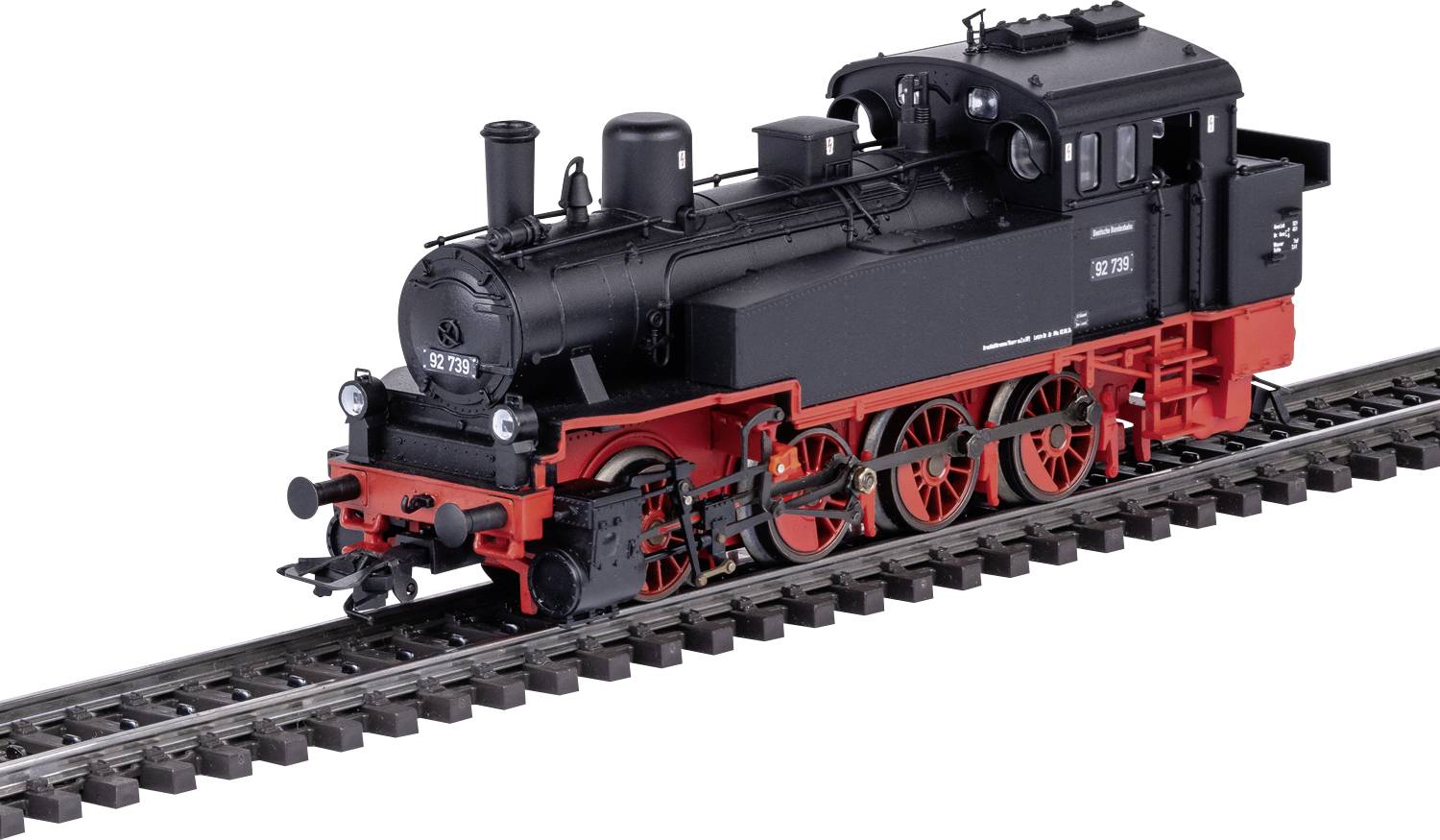Une locomotive à vapeur miniature en noir et rouge sur une section de voie ferrée. La locomotive présente des détails typiques tels que la chaudière et les roues.