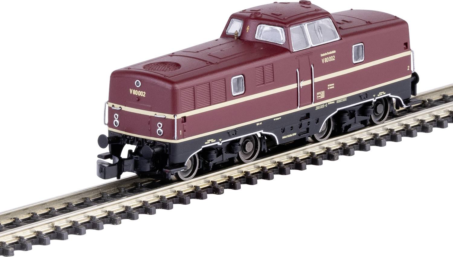 Un modèle d'une locomotive diesel rouge sur un morceau de rail. La locomotive présente des bandes beiges, offre des détails réalistes et est à l'échelle miniature.