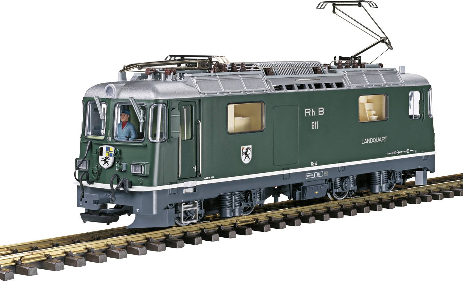 Un train vert portant l'inscription 'RhB 611 LAUD/VAULT' circule sur une voie. Une personne est visible dans la cabine de conduite.