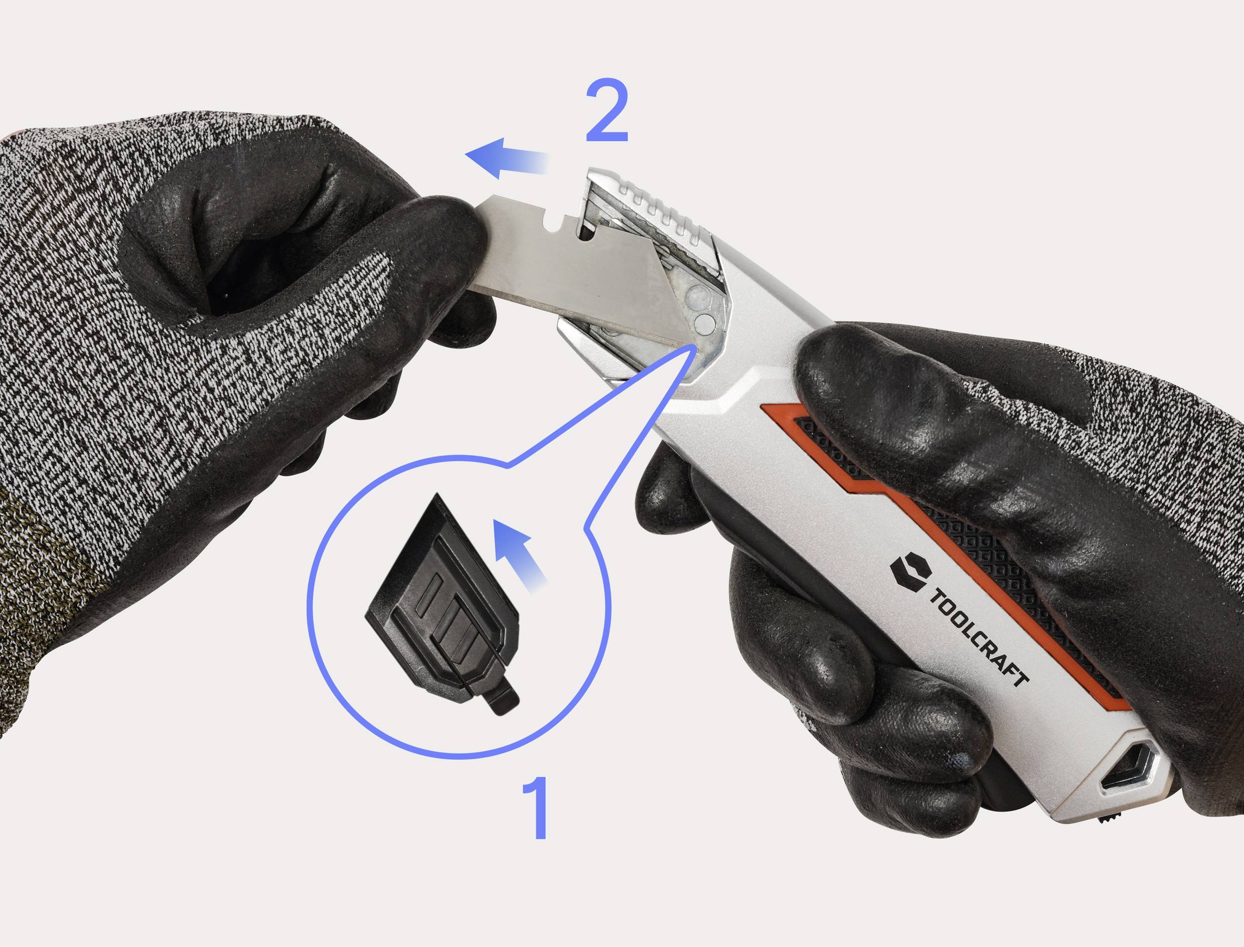 Une personne portant des gants remplace une lame de couteau utilitaire à l'aide d'un compartiment de rangement mis en évidence avec des numéros 1 et 2 montrant les étapes.