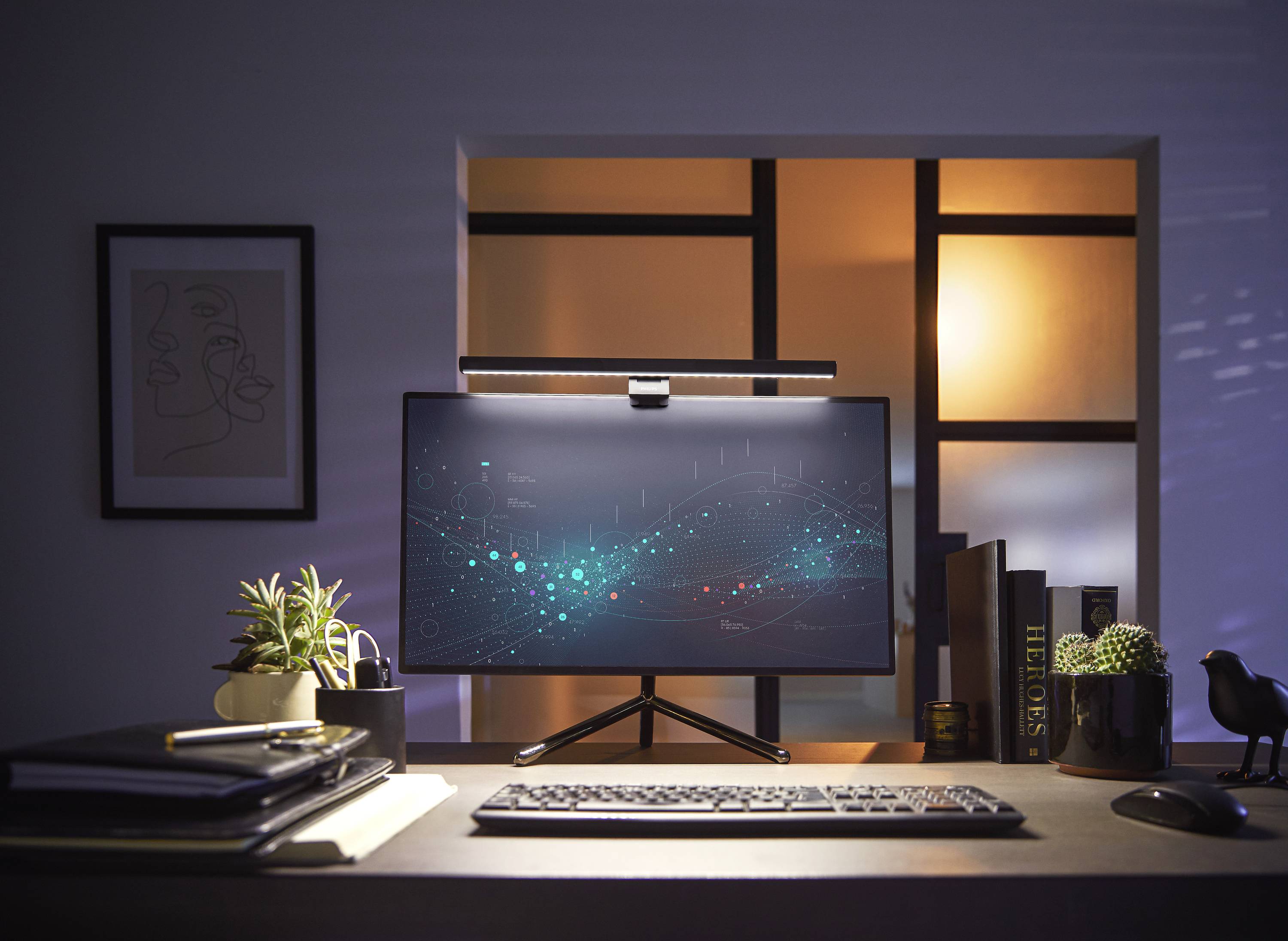 Un bureau moderne avec moniteur affiche un diagramme numérique devant une fenêtre éclairée. Des plantes et des livres décorent la pièce.
