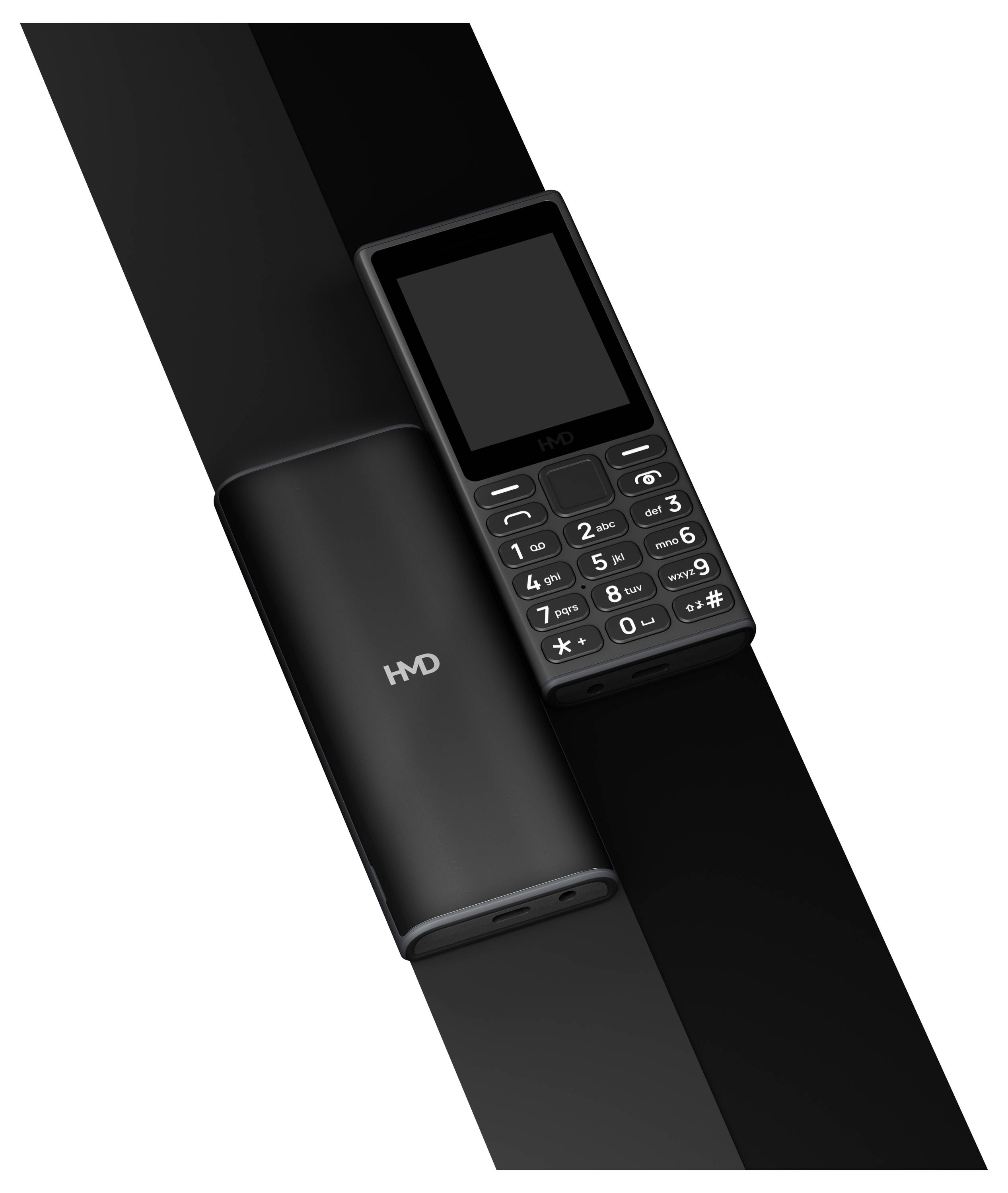 Un téléphone portable simple avec des touches, à côté d'un chargeur cylindrique, tous deux en noir et avec un design similaire.