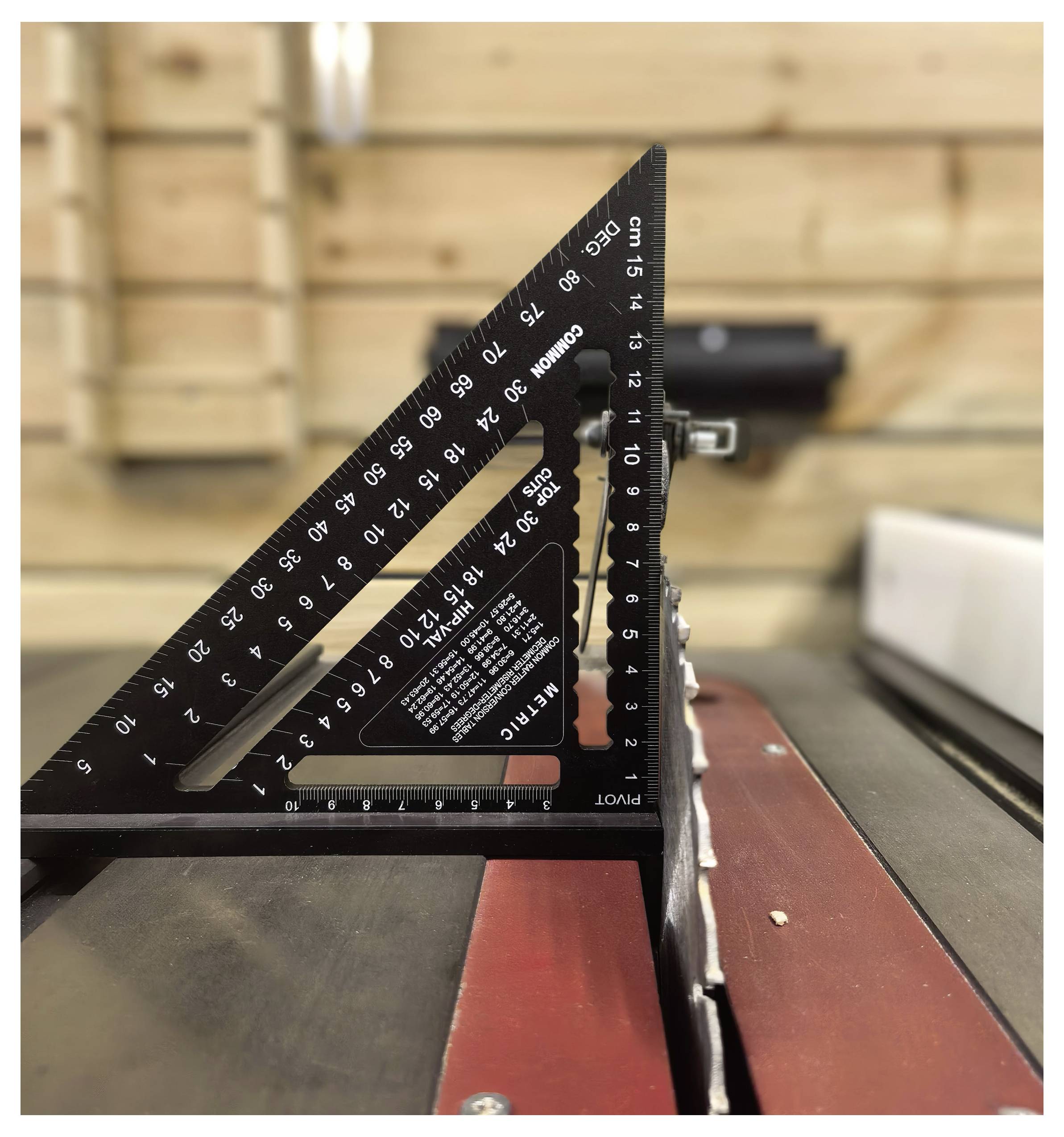 Un gros plan d'un outil de mesure noir, marqué avec « PIVOT », les chiffres 1-5, et un bord dentelé en dents de scie, possiblement utilisé pour des mesures d'angles précis.